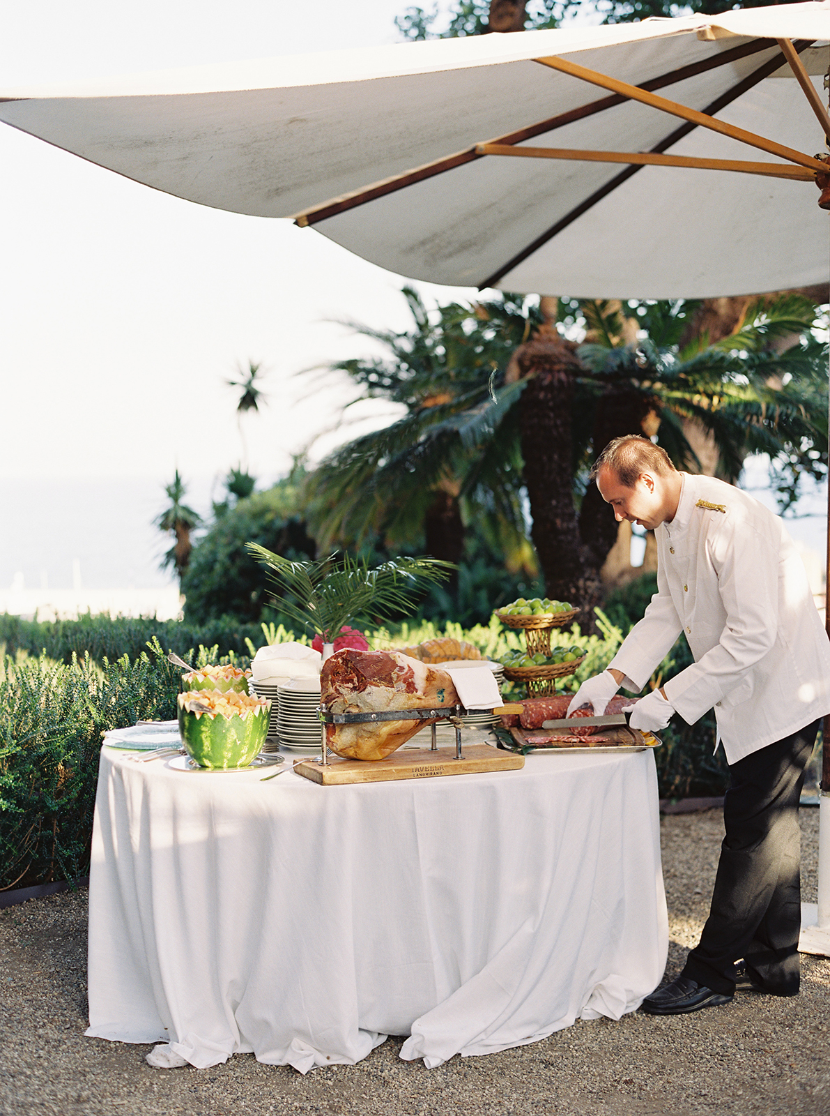 Outdoor wedding antipasto station with cured meats and fruit set in the gardens of Villa Durazzo, Santa Margherita Ligure