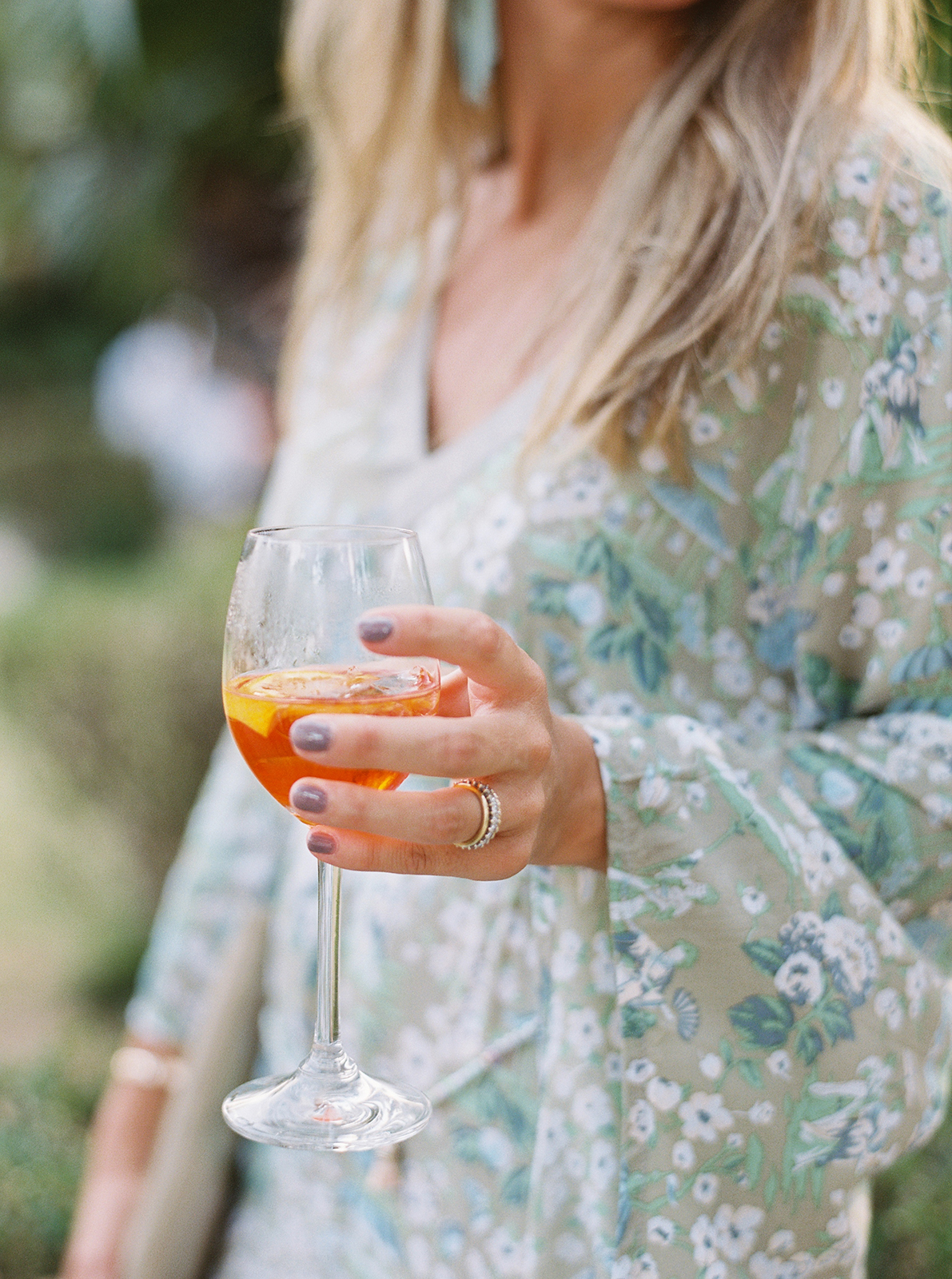 Guest holding an Aperol spritz during an outdoor Villa Durazzo wedding celebration