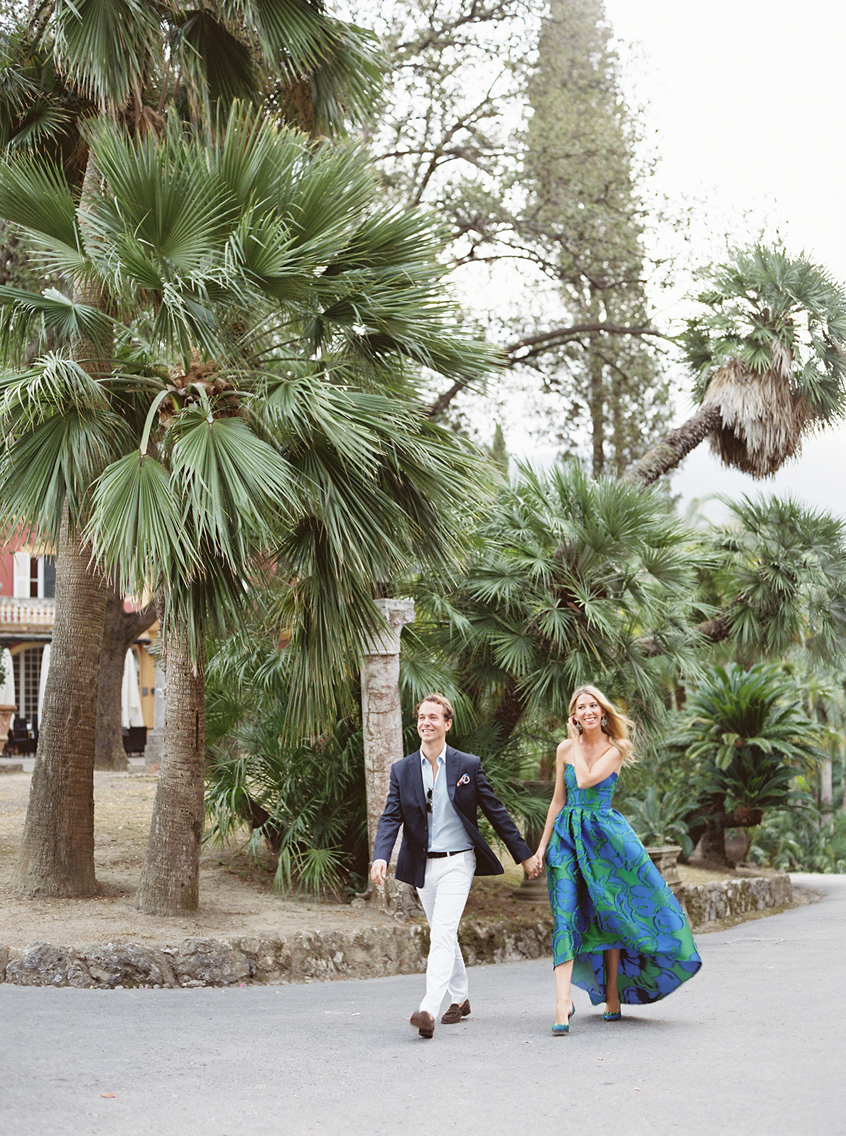 Couple walking hand in hand through palm gardens at Villa Durazzo in Santa Margherita Ligure