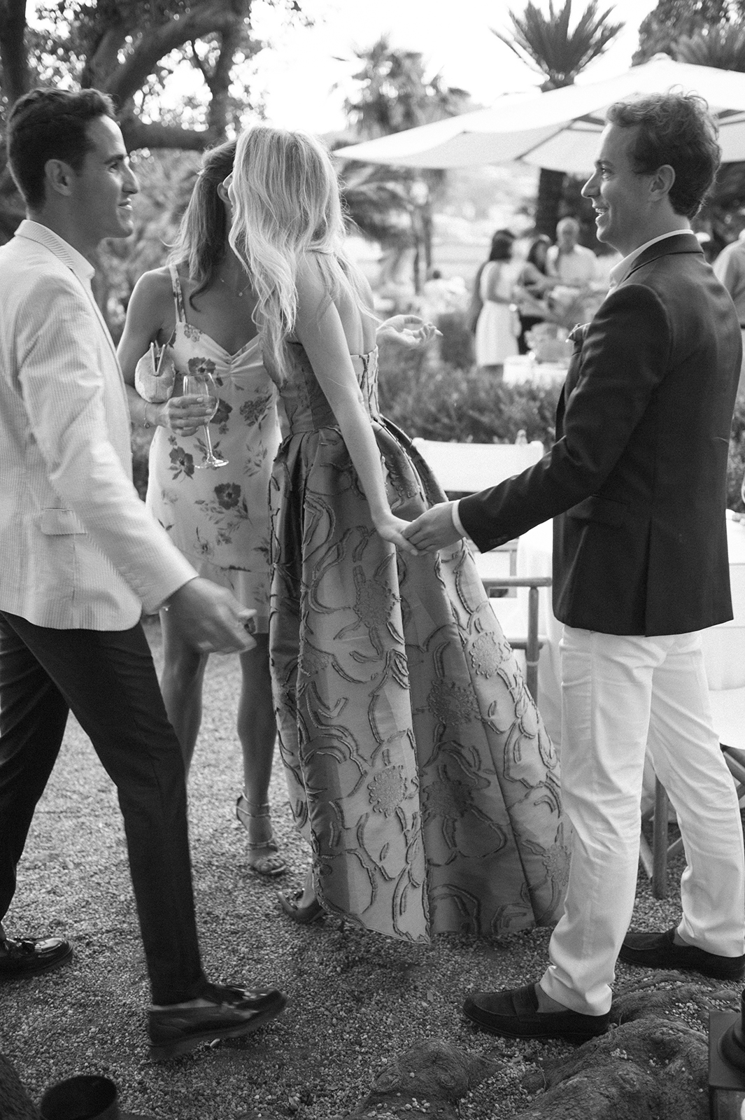 Black and white candid of wedding guests socializing during welcome dinner in Italy