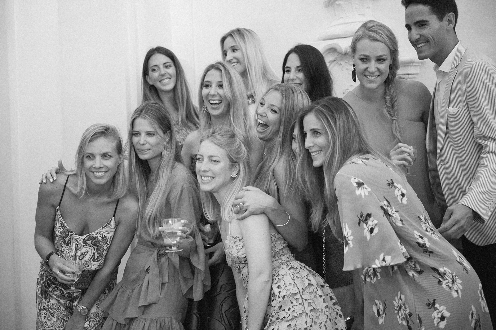 Black and white photo of a joyful group of women gathered closely together during a wedding party