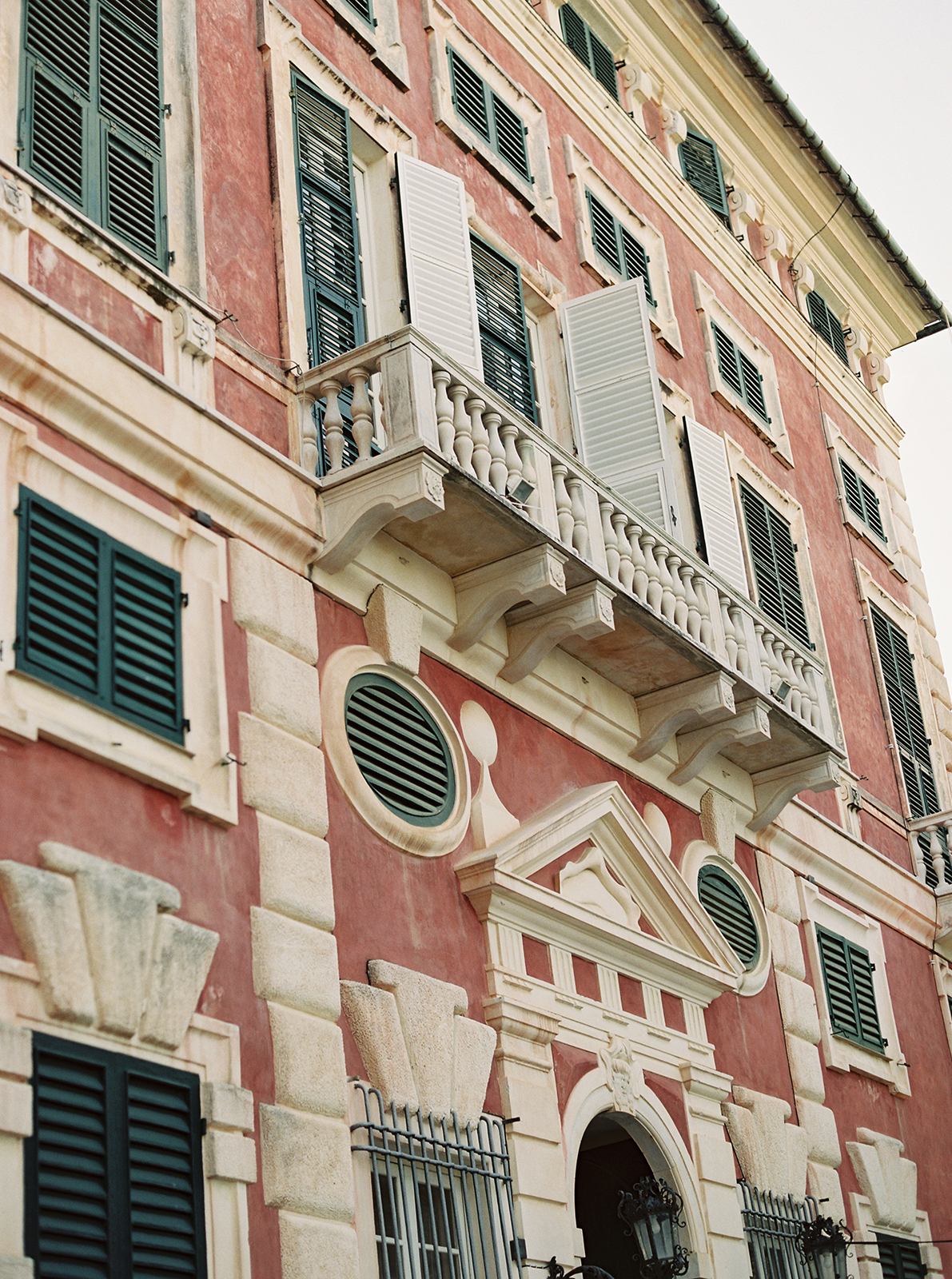 Historic pink façade of Villa Durazzo in Santa Margherita Ligure framed by palm trees