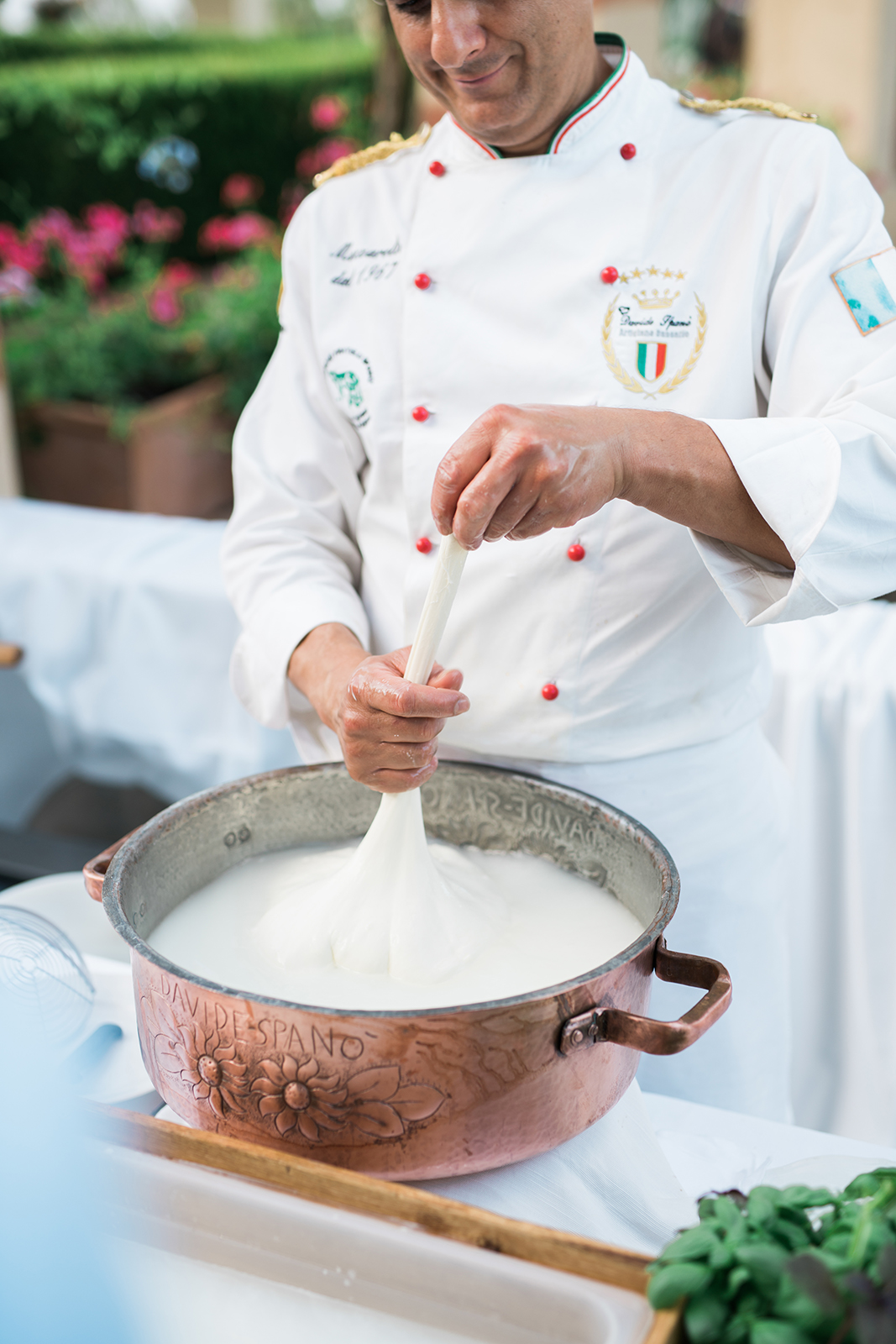 Chef preparing fresh cheese in a copper pot during a wedding reception culinary experience
