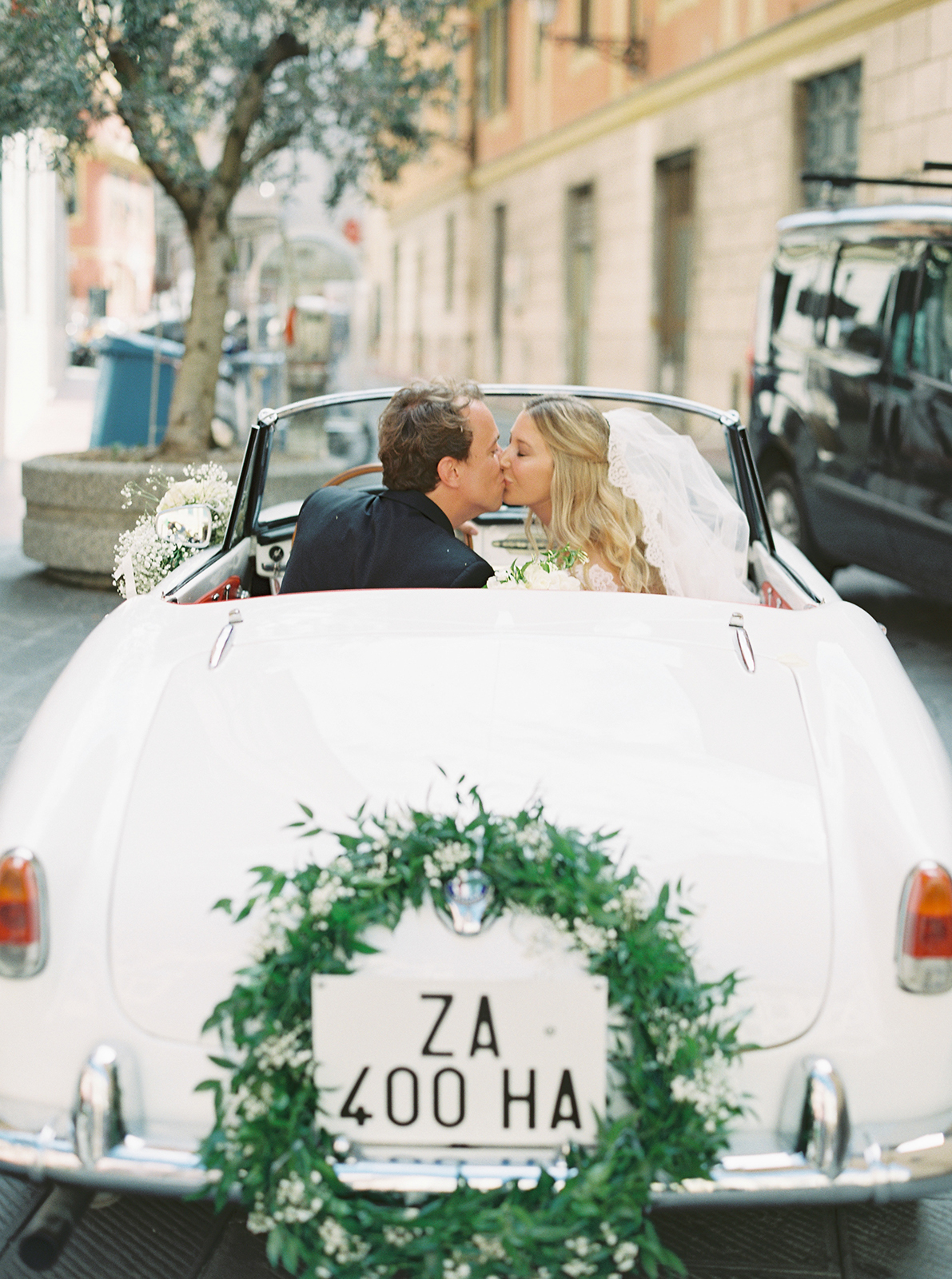 Bride and groom kissing in vintage convertible during Imperiale Palace Hotel Portofino wedding