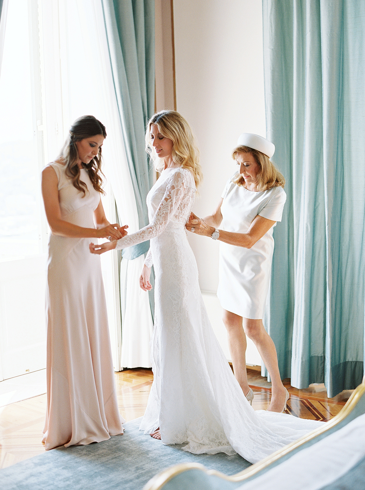 Bride being helped into lace wedding dress inside Imperiale Palace Hotel in Portofino