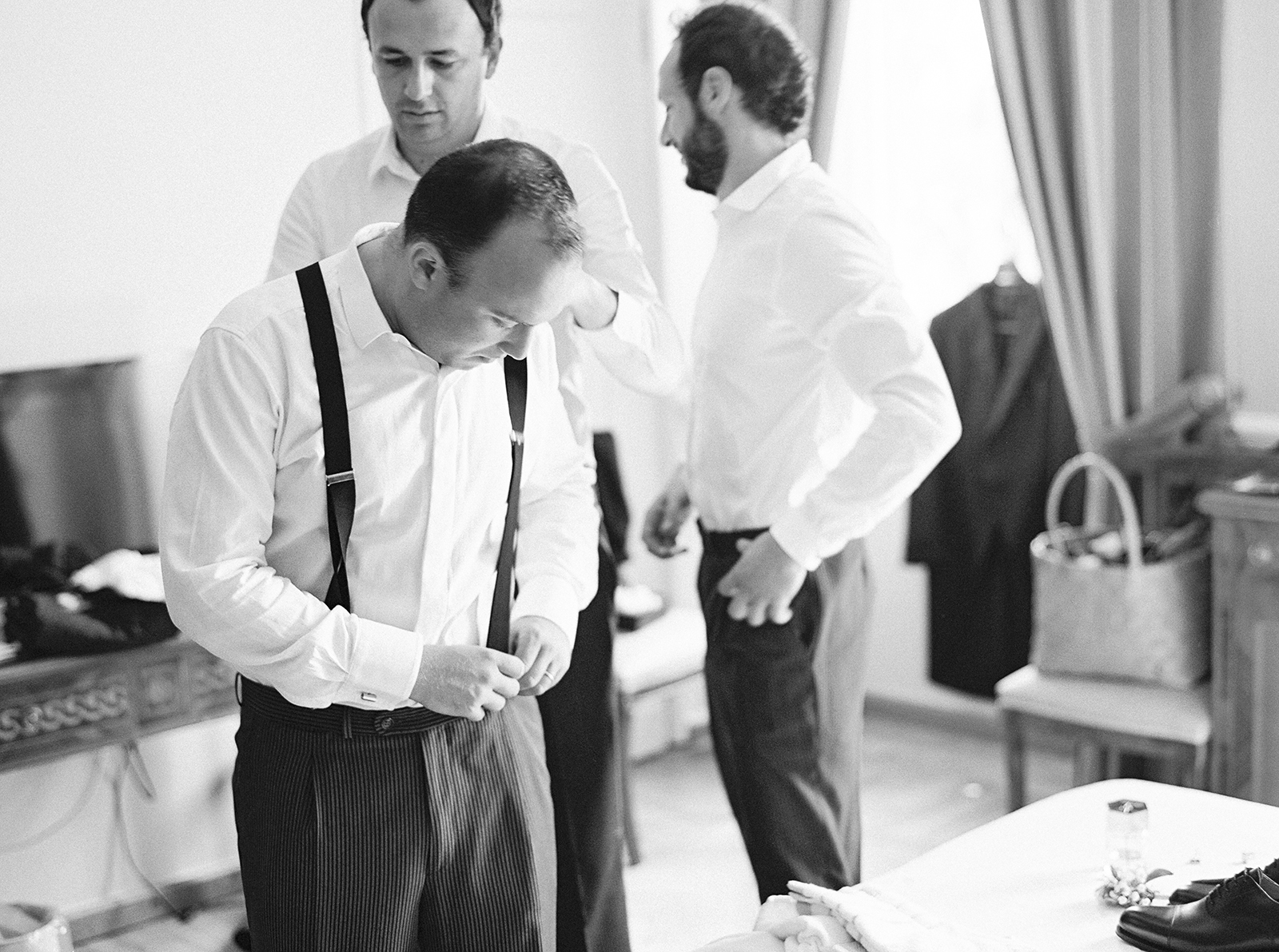 Groom getting ready with groomsmen inside Imperiale Palace Hotel in Portofino in black and white