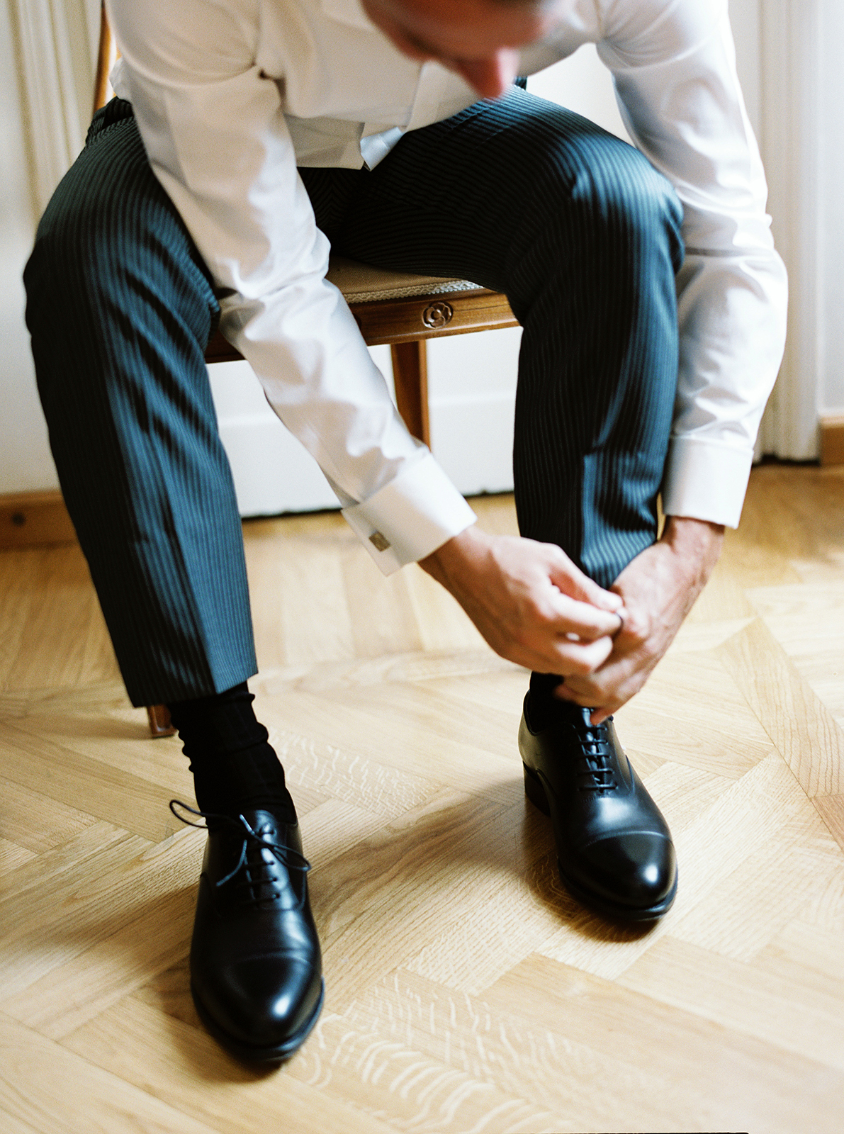 Groom tying dress shoes during wedding preparations at Imperiale Palace Hotel in Portofino