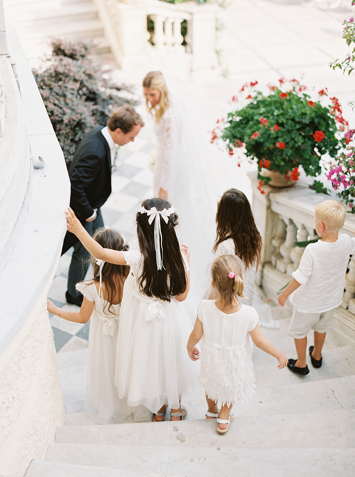 Flower girls walking down marble steps during wedding at Imperiale Palace Hotel in Portofino