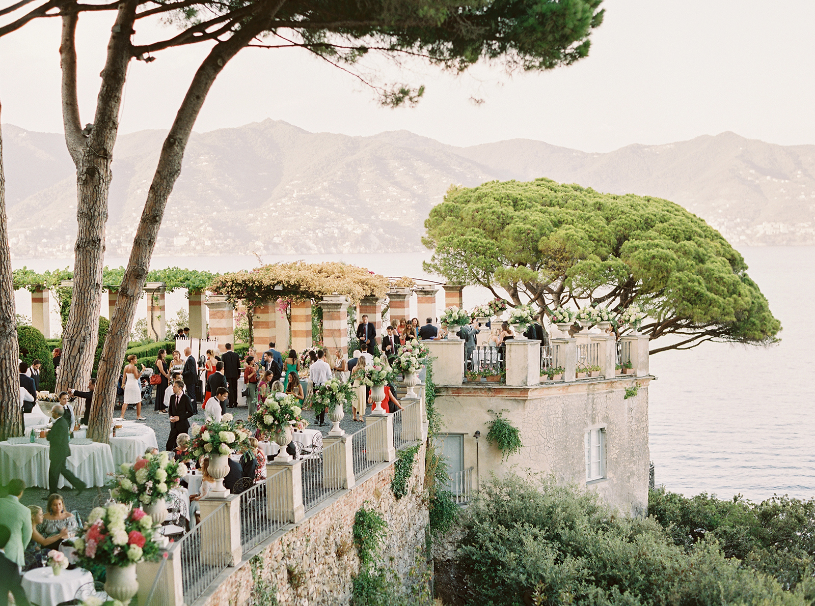 Wedding guests enjoying cocktail hour on the terrace at La Cervara in Portofino with views of the Mediterranean Sea