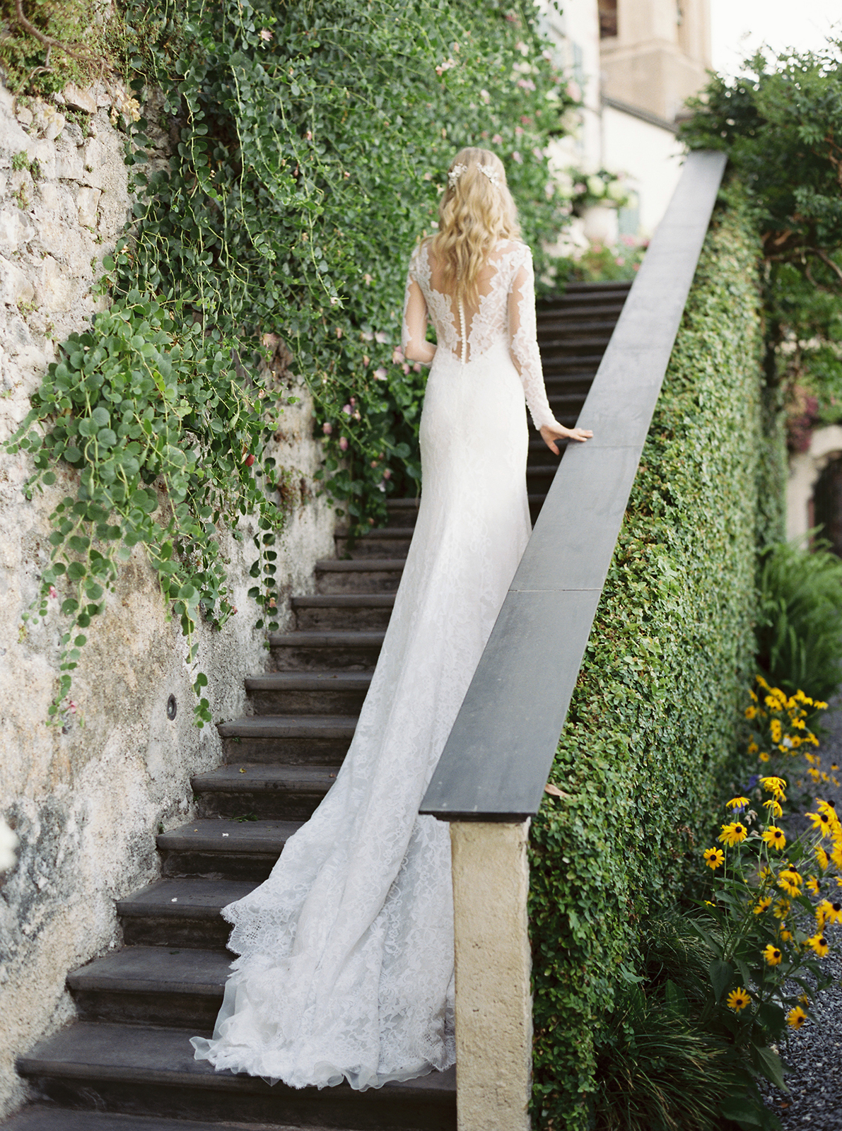 Bride walking up garden stone steps showing lace back wedding dress at La Cervara Portofino