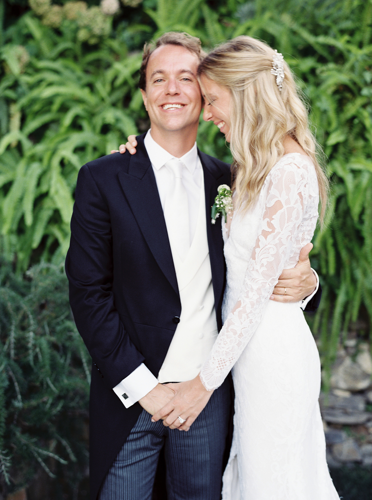 Joyful bride and groom portrait surrounded by greenery in La Cervara