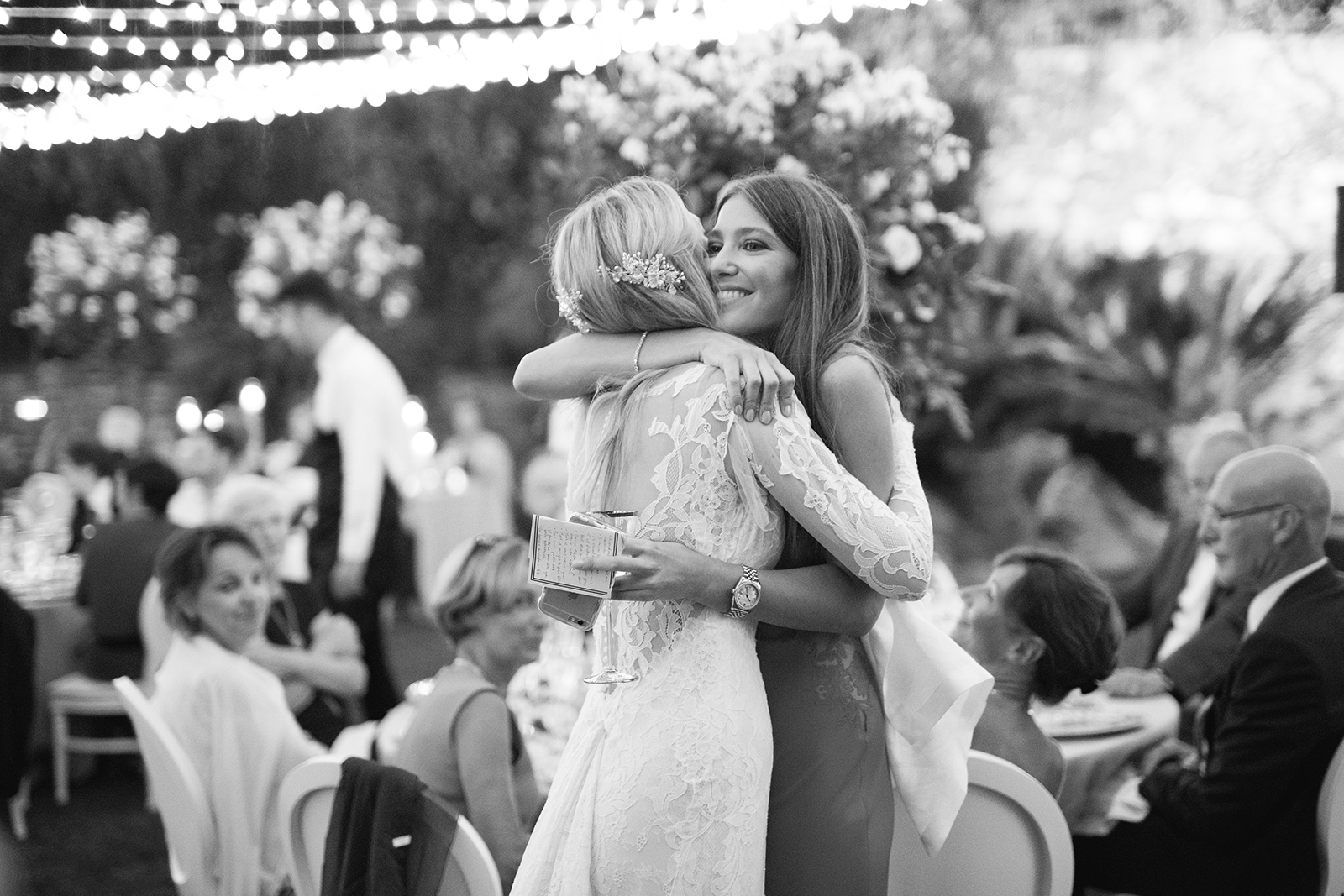 Black and white image of the bride hugging a guest during an emotional moment at the wedding reception