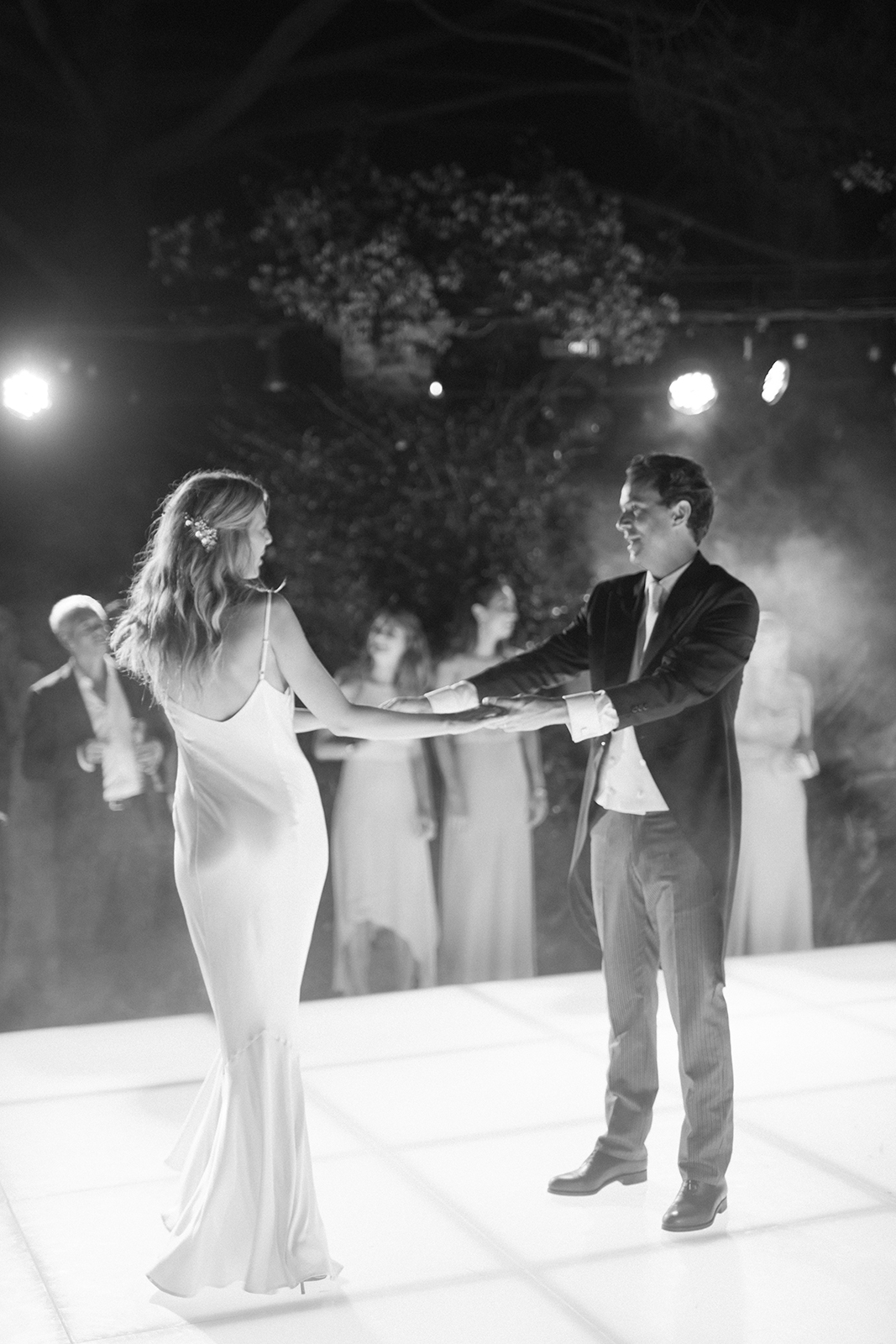 Black and white photograph of bride and groom dancing together during their wedding reception