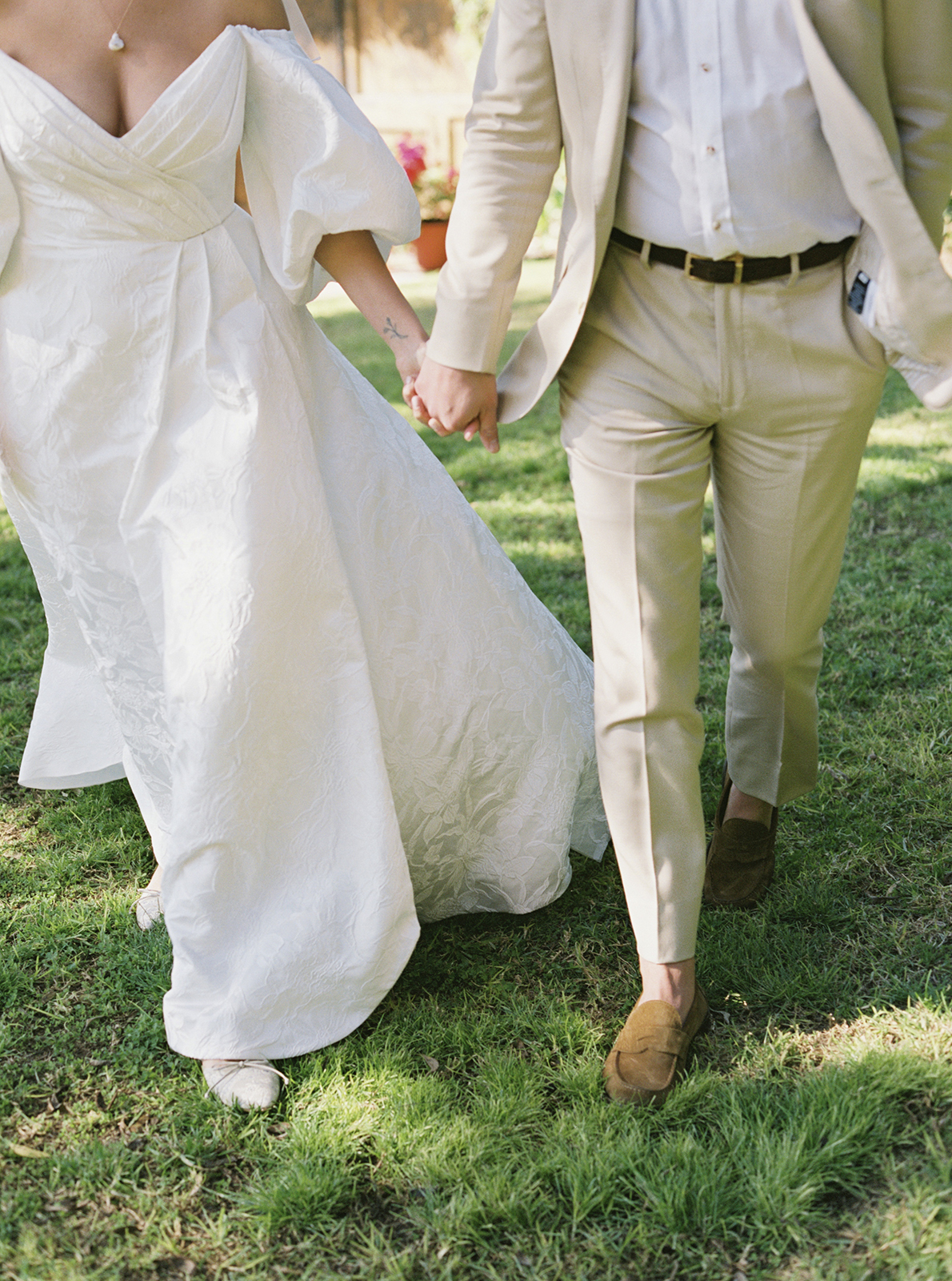 Wedding couple holding hands while walking through garden at Casa de Sierra Nevada