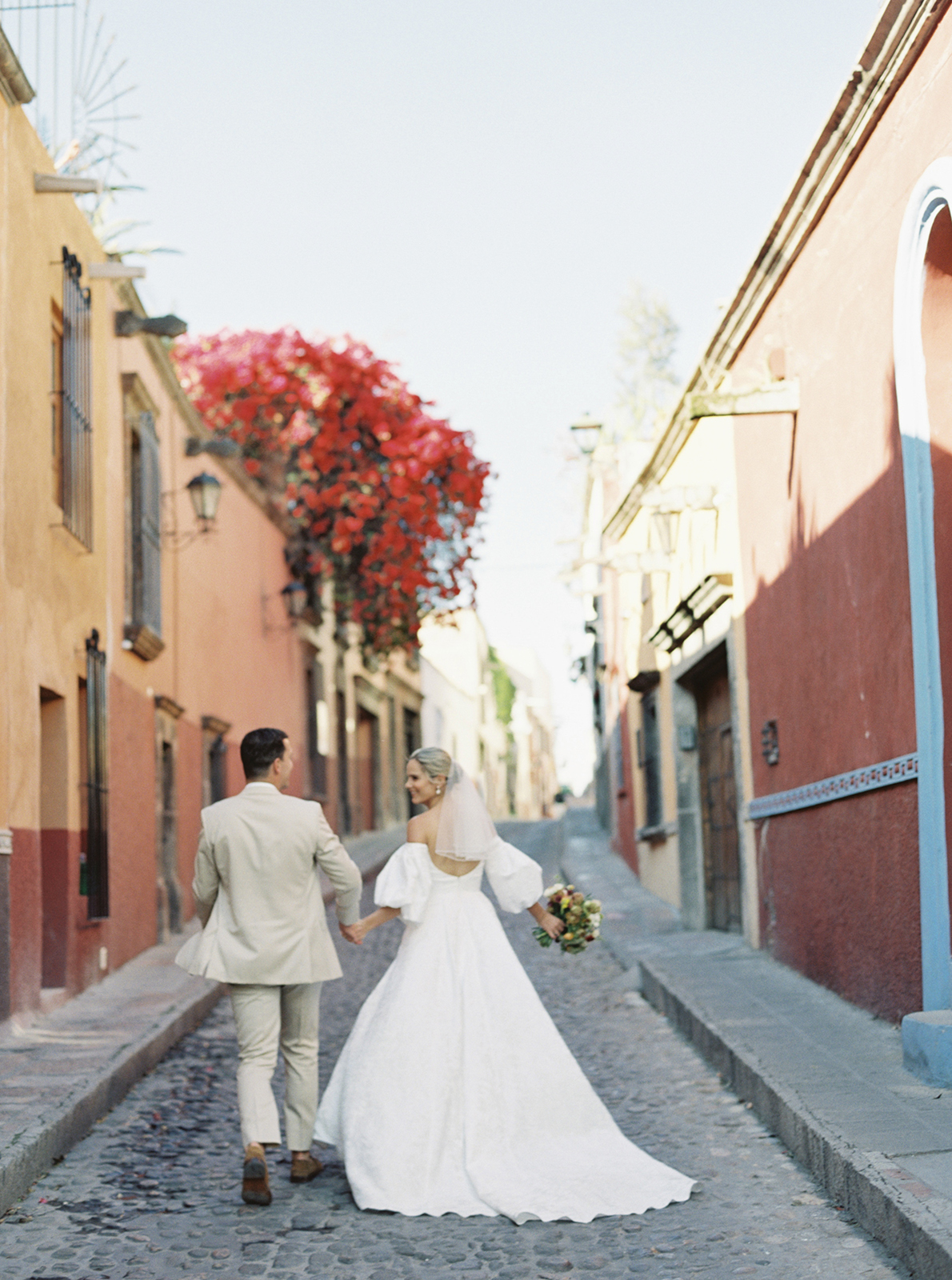 Wedding couple walking hand in hand through San Miguel de Allende street