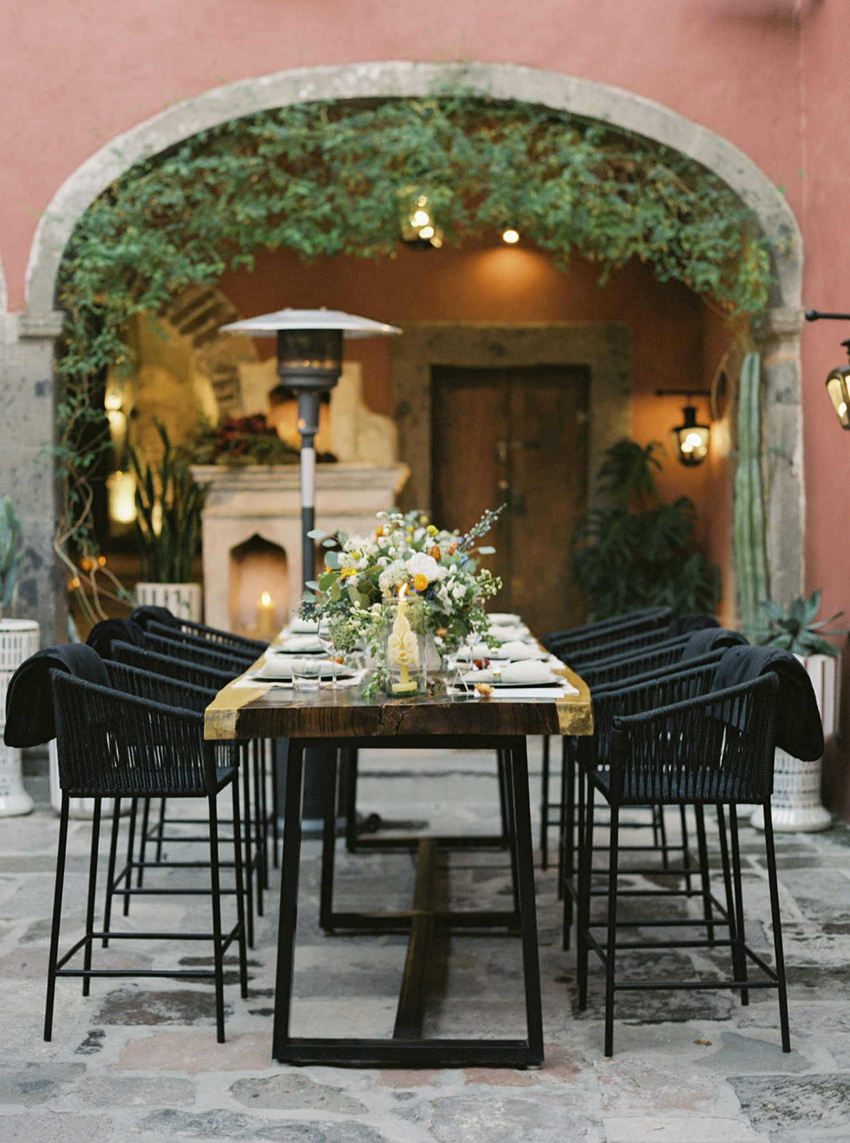 Long wedding dinner table at Casa Hoyos styled with greenery, candles, and intimate lighting