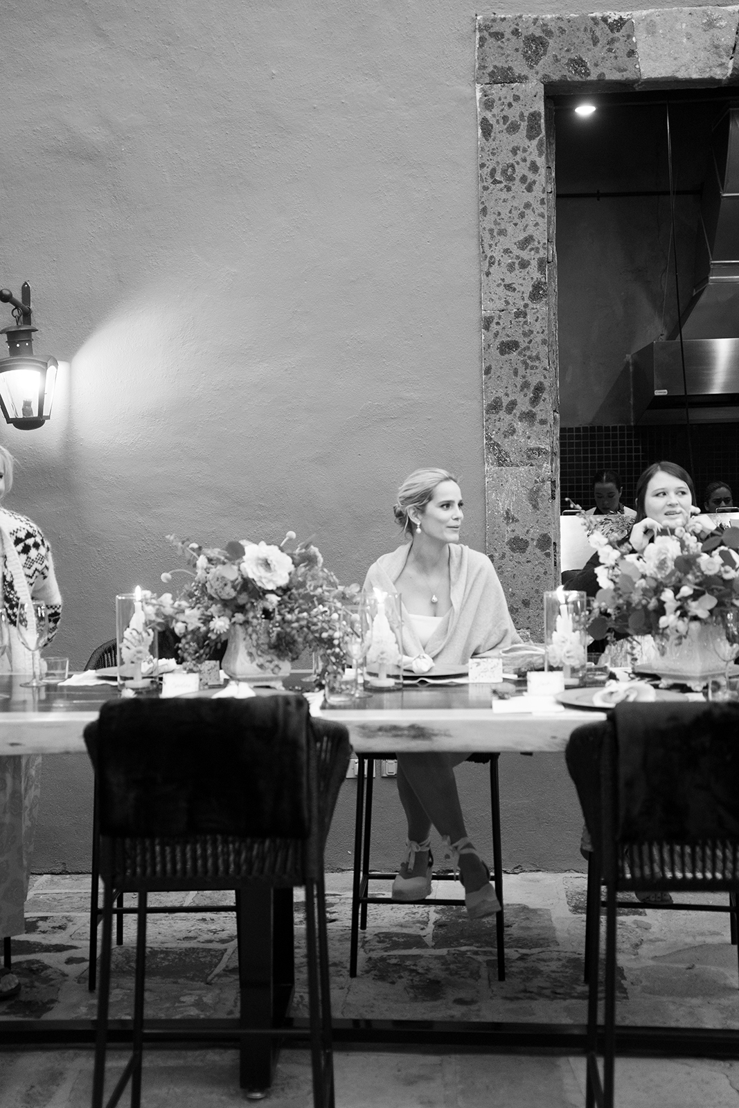 Black and white image of bride seated at dinner table during Casa Hoyos wedding reception