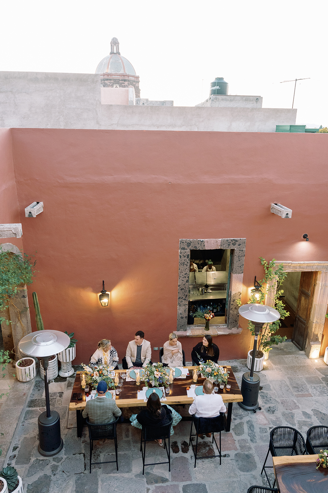Overhead view of wedding guests seated at candlelit dinner table at Casa Hoyos