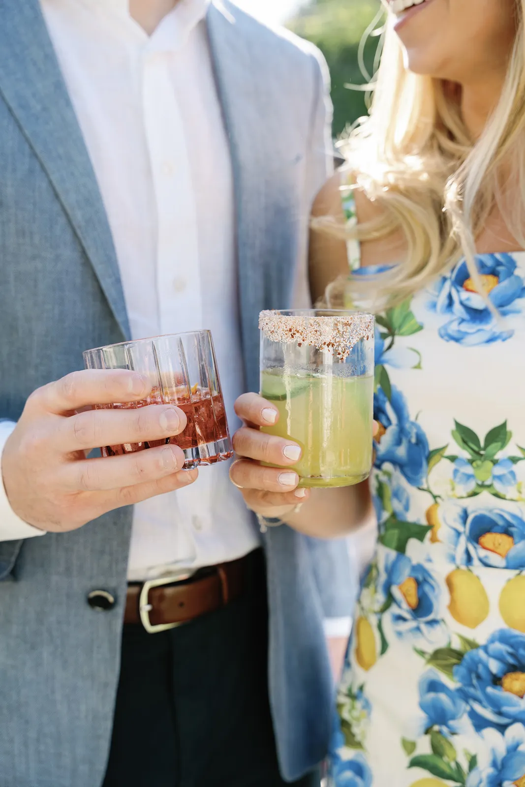 Close-up of the bride and groom holding cocktails together during the rehearsal dinner