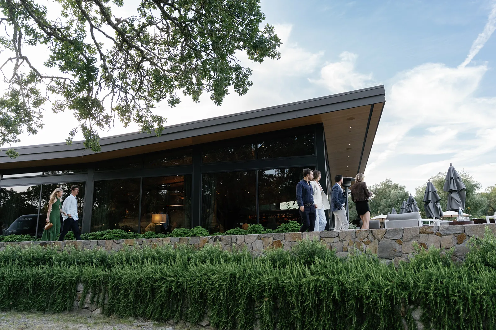 Guests walking toward a modern building in Montage Healdsburg as they arrive for a rehearsal dinner gathering