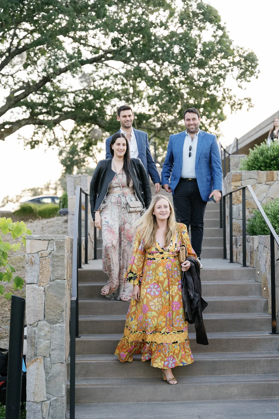 Wedding guests walking down outdoor steps while arriving at the rehearsal dinner