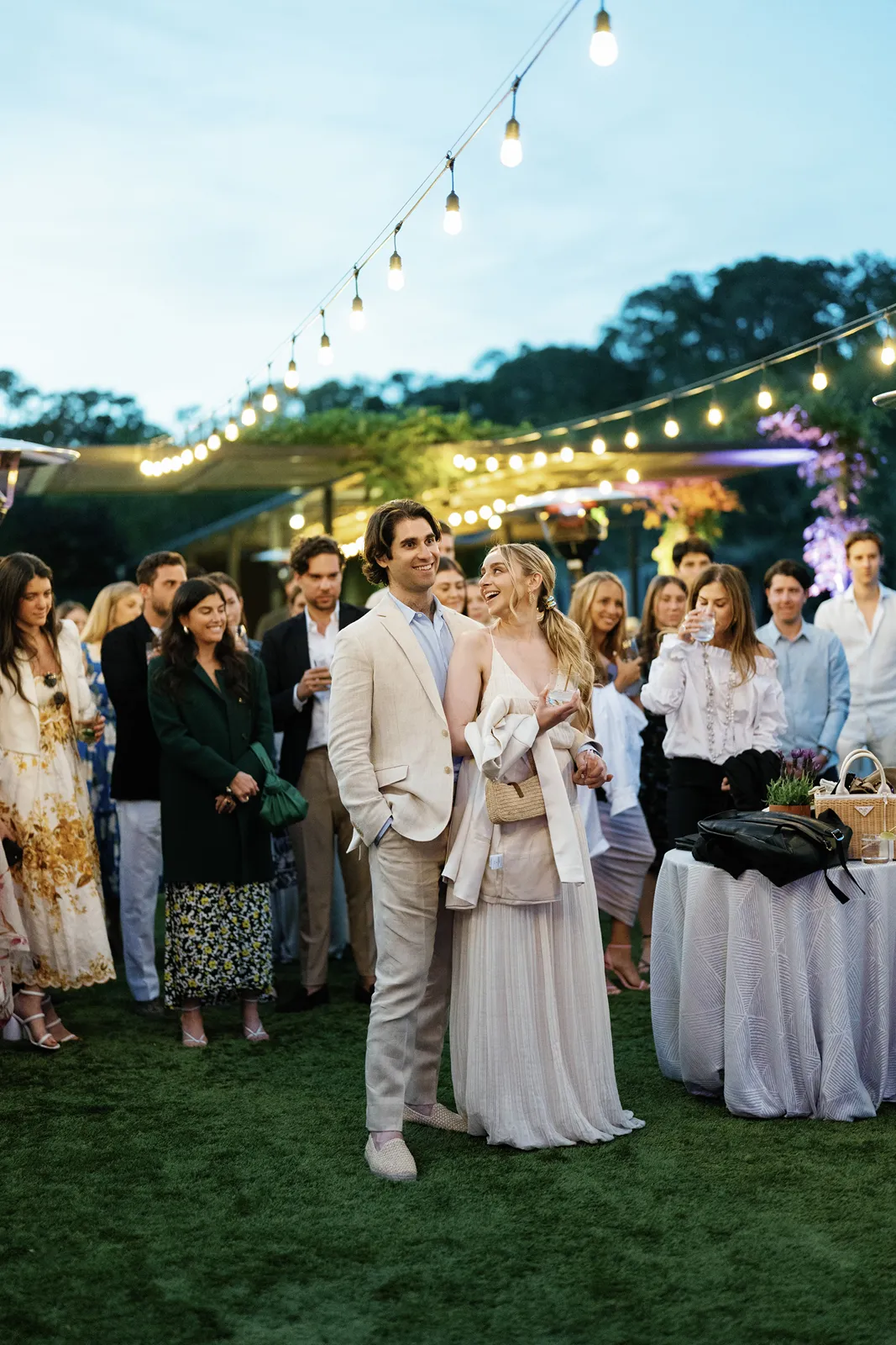 Bride and groom standing together under string lights during a Sonoma rehearsal dinner