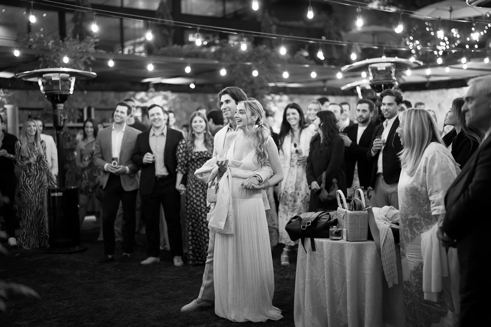Bride and groom reacting with laughter as guests gather during a Sonoma rehearsal dinner