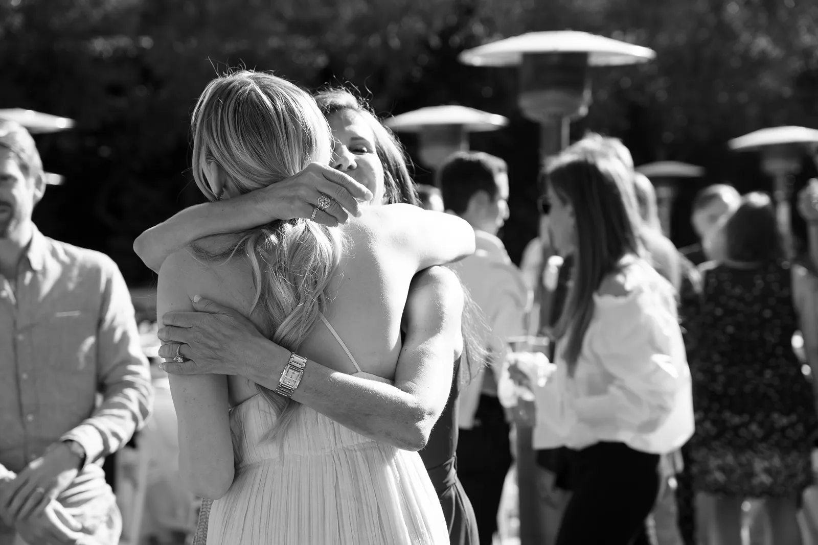 Guests sharing an emotional hug during a Sonoma rehearsal dinner