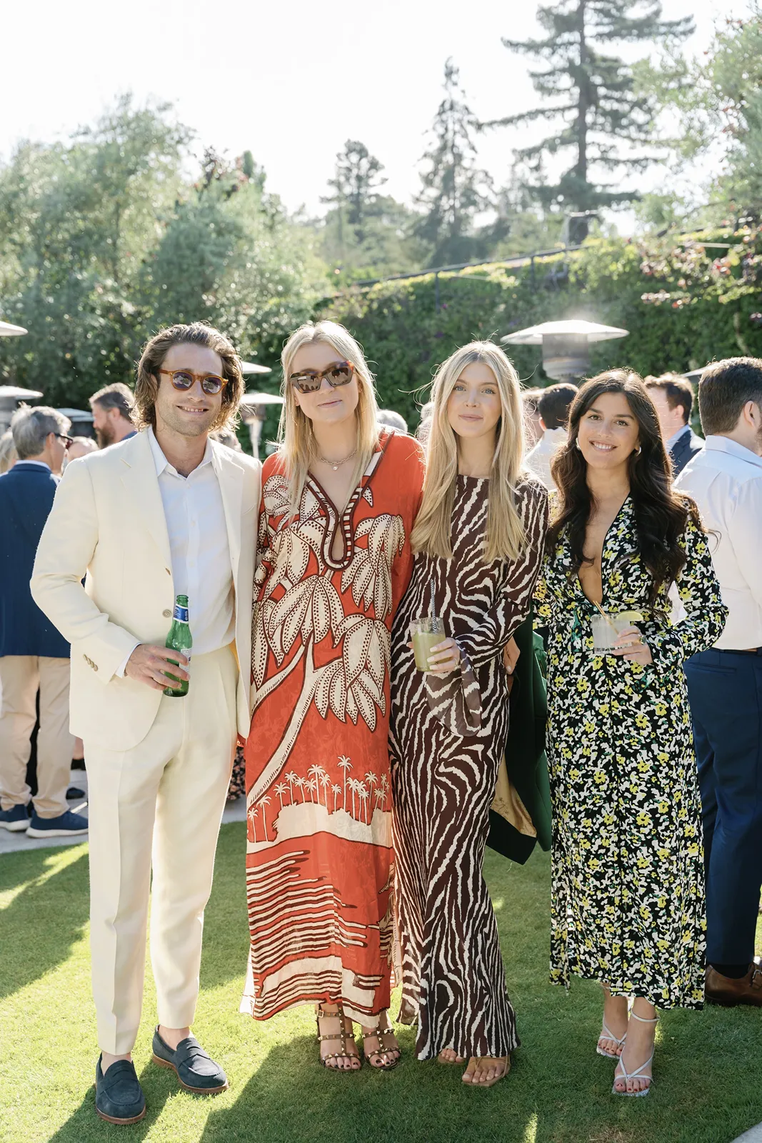 Friends posing together with drinks during a sunny Sonoma rehearsal dinner