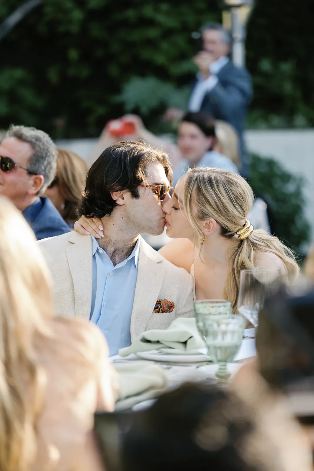 Couple sharing a kiss at their wine country rehearsal dinner table