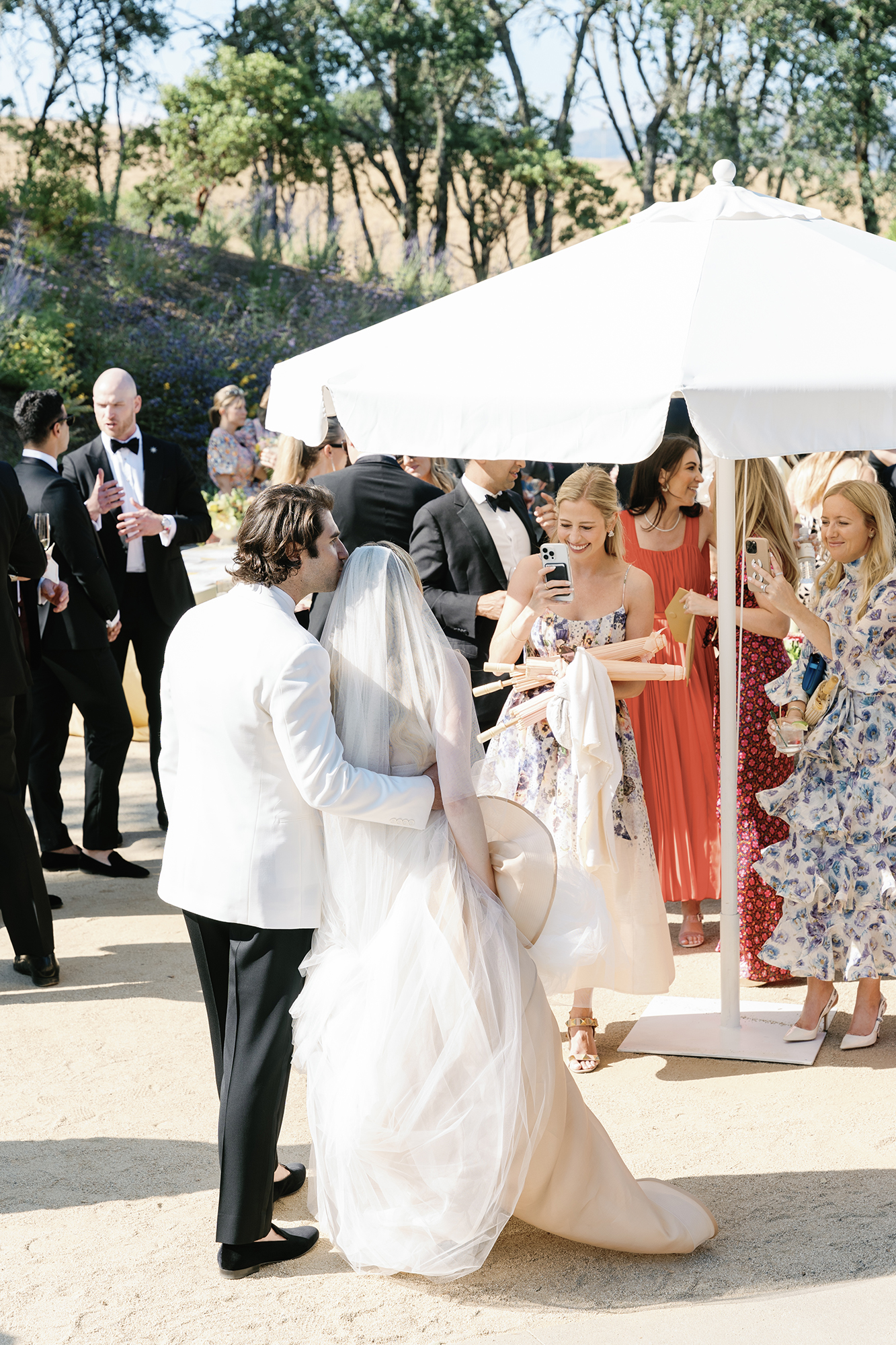 wedding guests taking photos of the couple during cocktail hour