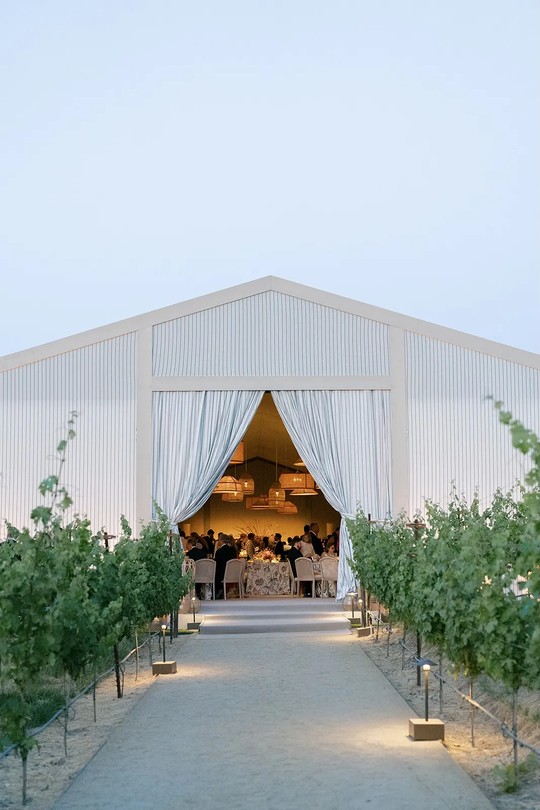 Montage Healdsburg wedding tent glowing at dusk with guests visible inside through dramatic draped entrance