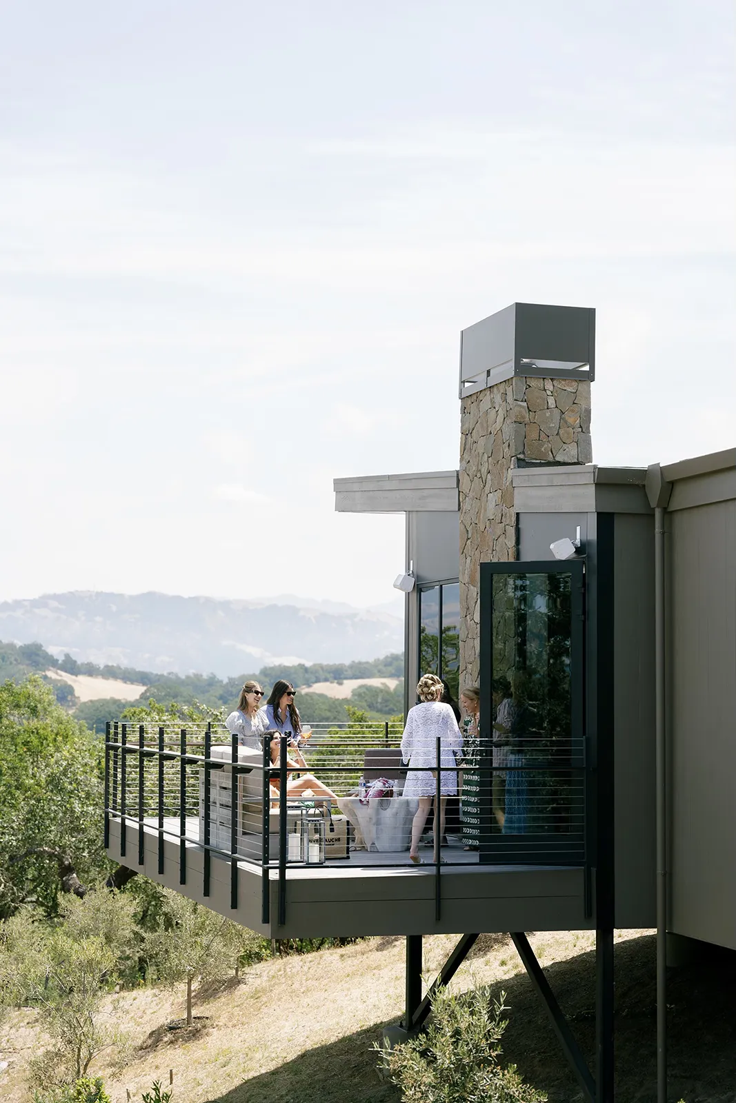 Bridesmaids relaxing on a balcony during wedding morning preparations overlooking the Sonoma hills.