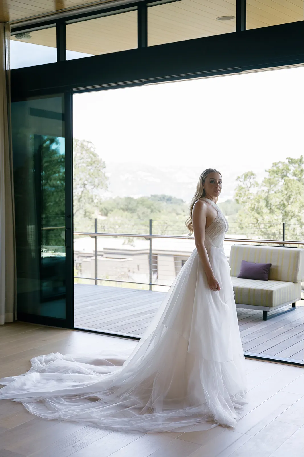 Bride standing in a flowing wedding gown on a private terrace at Montage Healdsburg with vineyard and hillside views in the background
