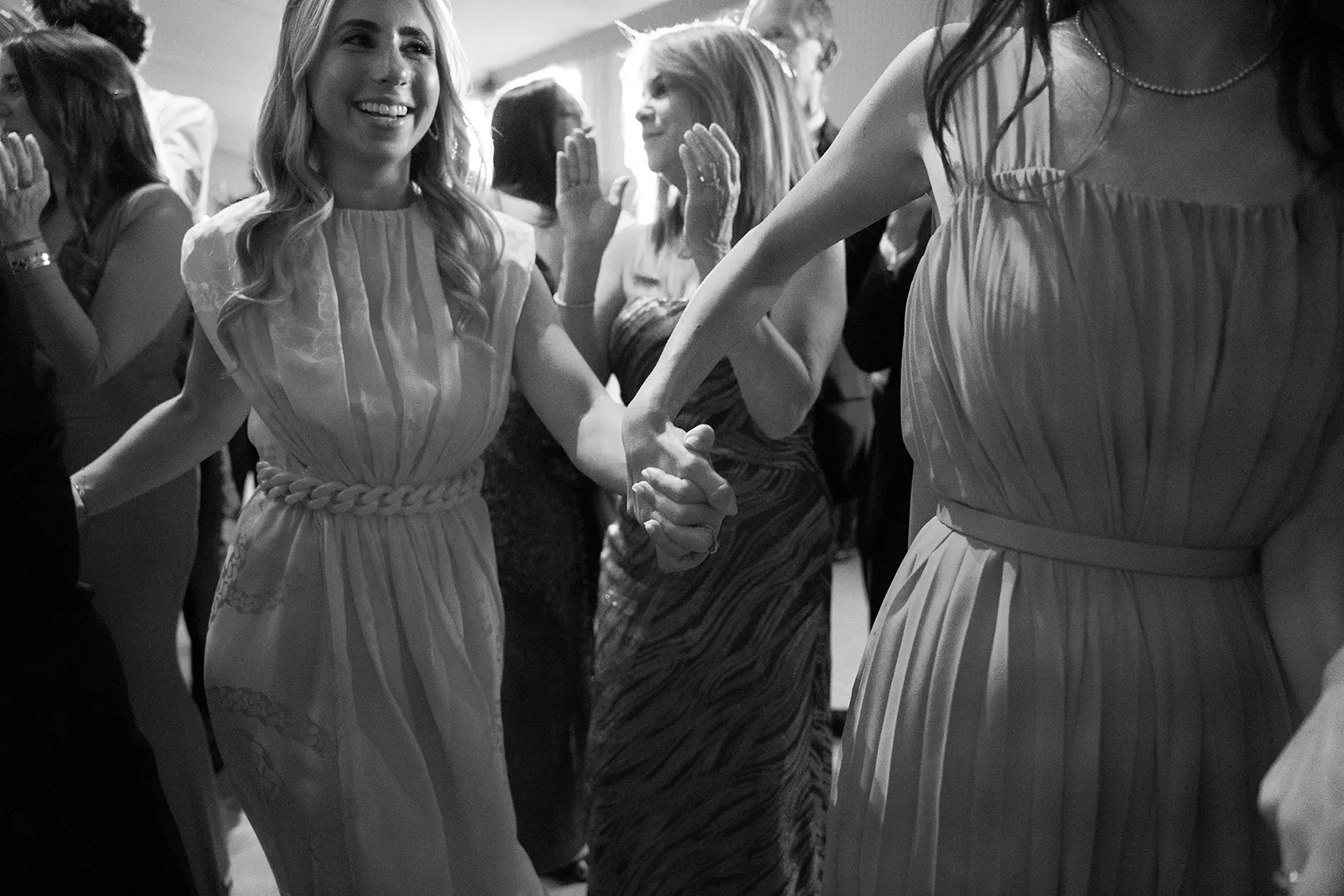Wedding guests holding hands and dancing together during the reception