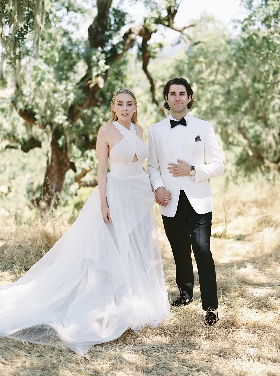 Bride and groom standing together beneath oak trees during wedding portraits at Montage Healdsburg