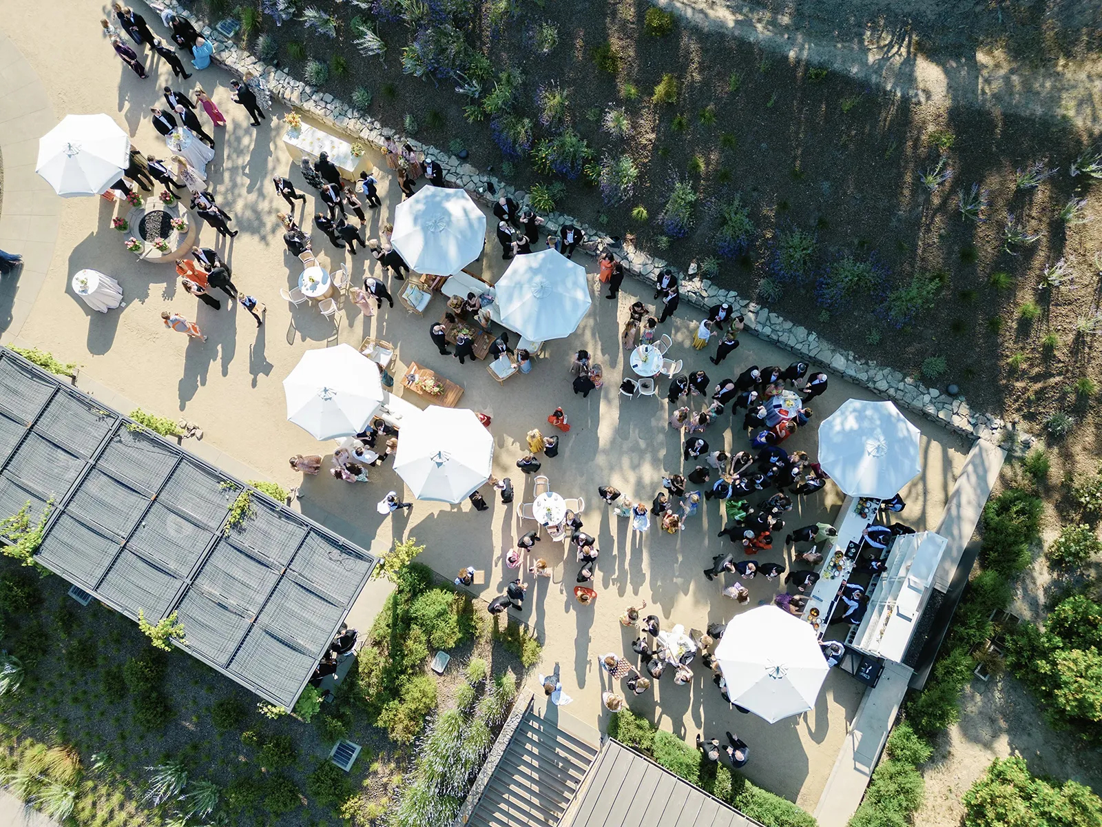 Aerial view of outdoor wedding cocktail hour with white umbrellas at Montage Healdsburg