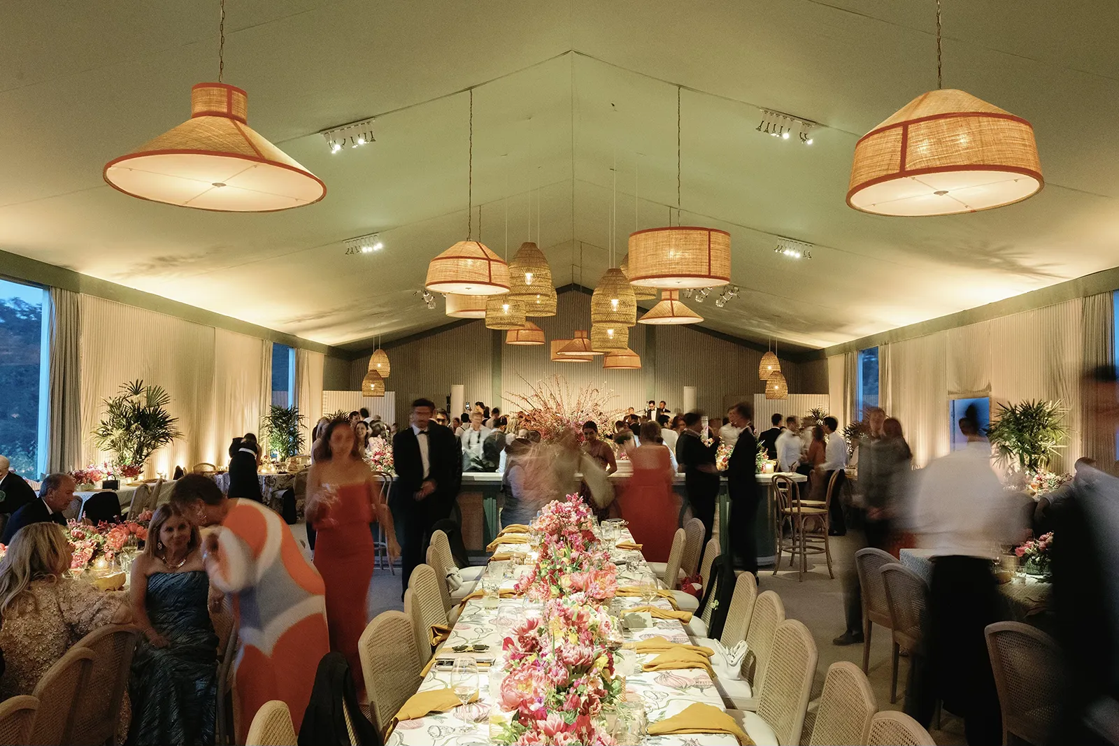 Guests seated at long banquet tables during a lively wedding reception with floral arrangements and ambient lighting at Montage Healdsburg