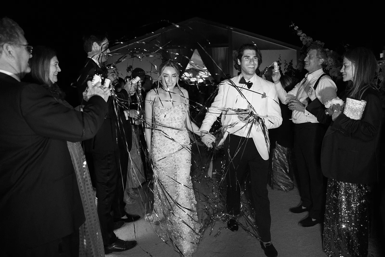 Bride and groom walking through a festive ribbon exit at night following their Montage Healdsburg wedding