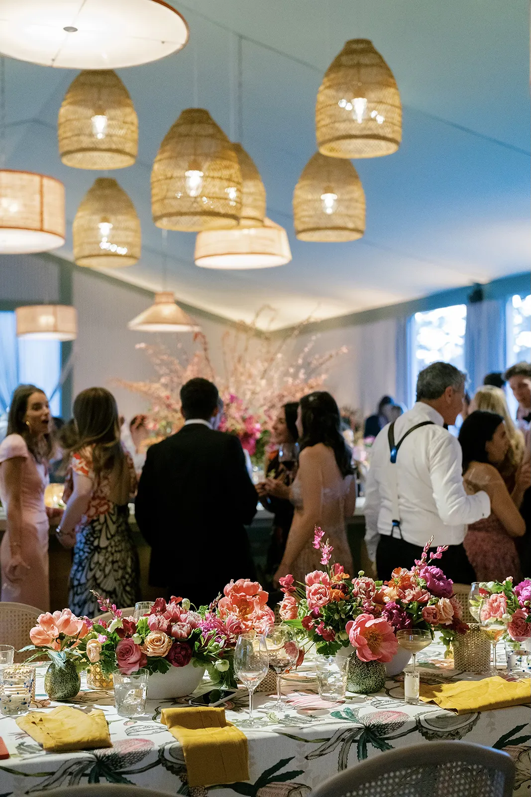 Wedding guest in a flowing rust-colored gown smiling near the reception bar