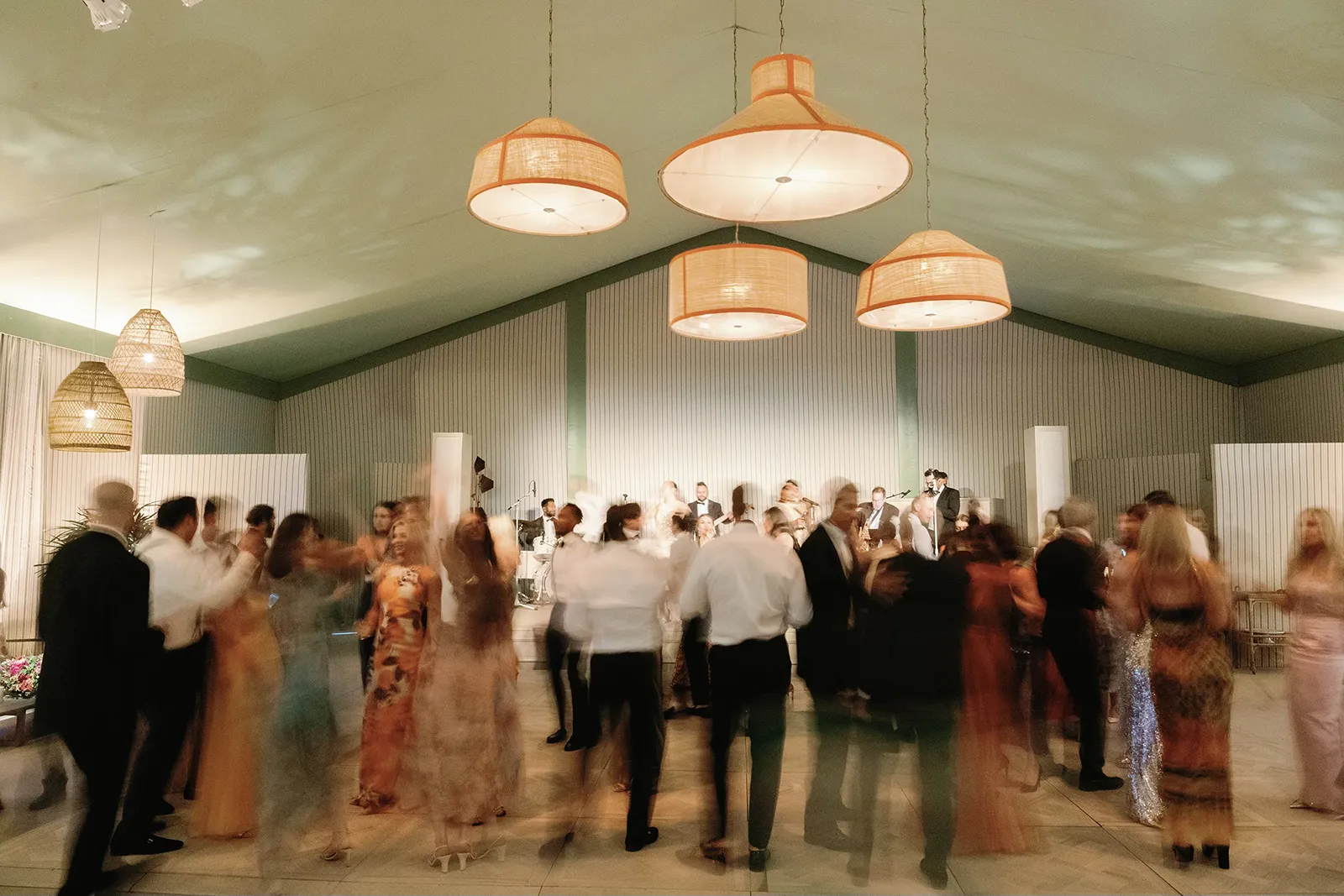 Wedding guests dancing together on a crowded reception floor beneath warm pendant lighting at Montage Healdsburg