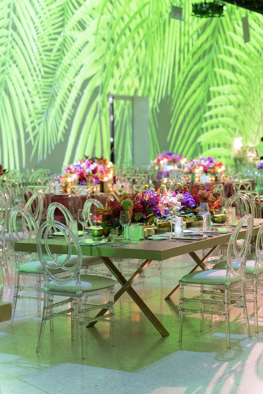 Elegant wedding reception tables with lush floral centerpieces and candlelight