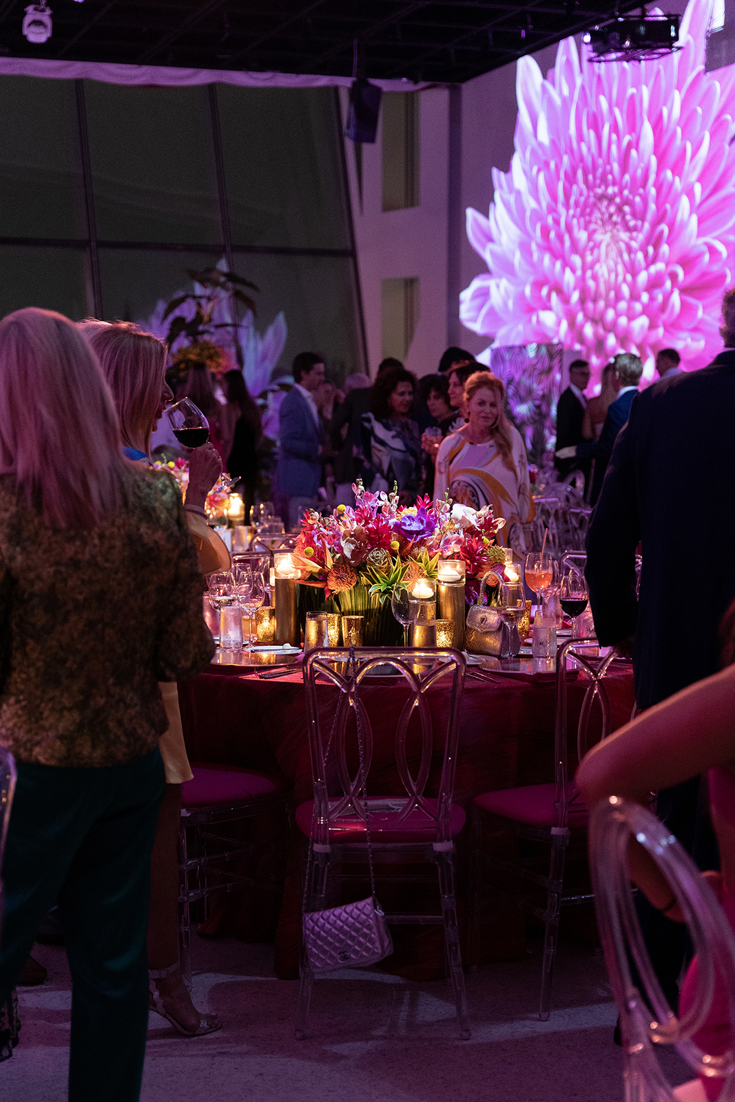 Wedding guests standing and socializing around candlelit reception tables