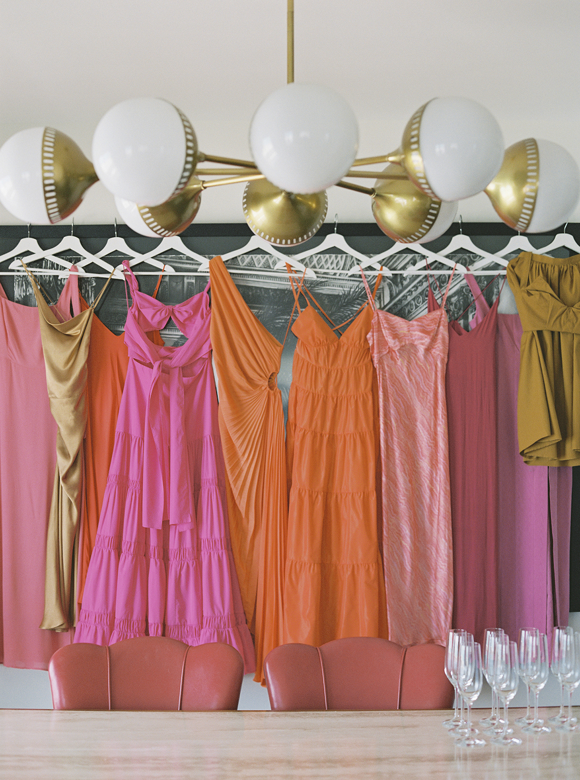 Colorful bridesmaid dresses hanging together in a Faena Hotel Miami Beach wedding suite