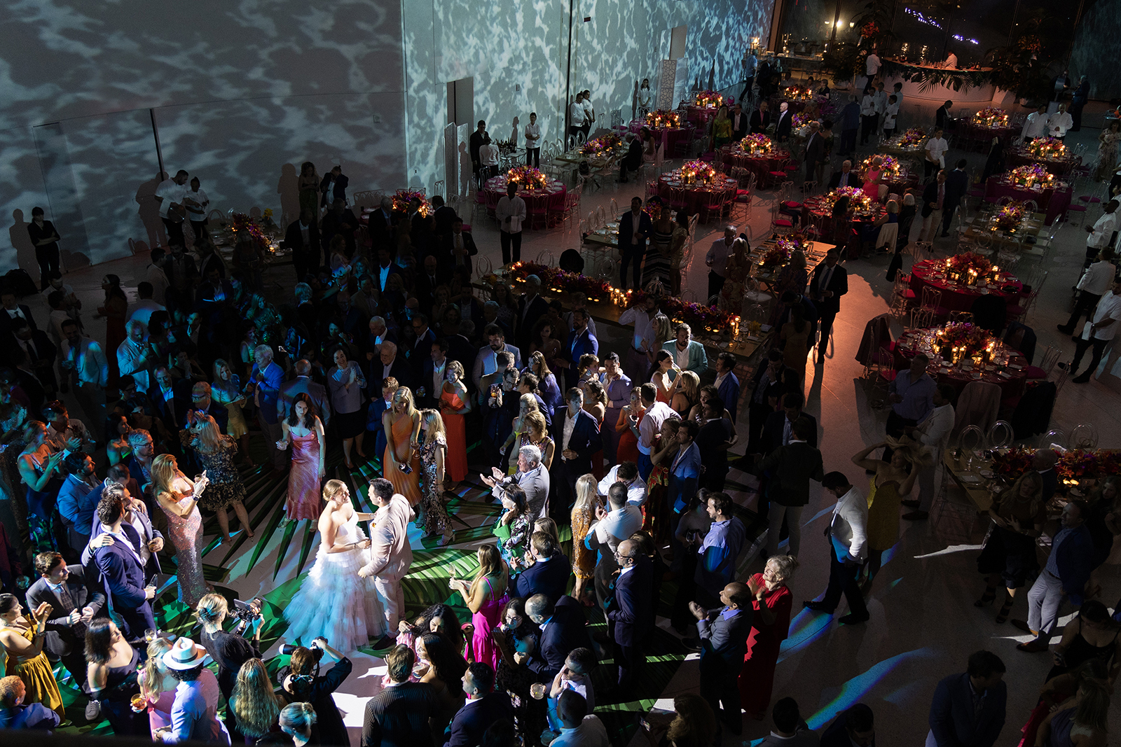 Overhead view of a lively Faena Miami Beach wedding reception as guests surround the couple during their first dance.