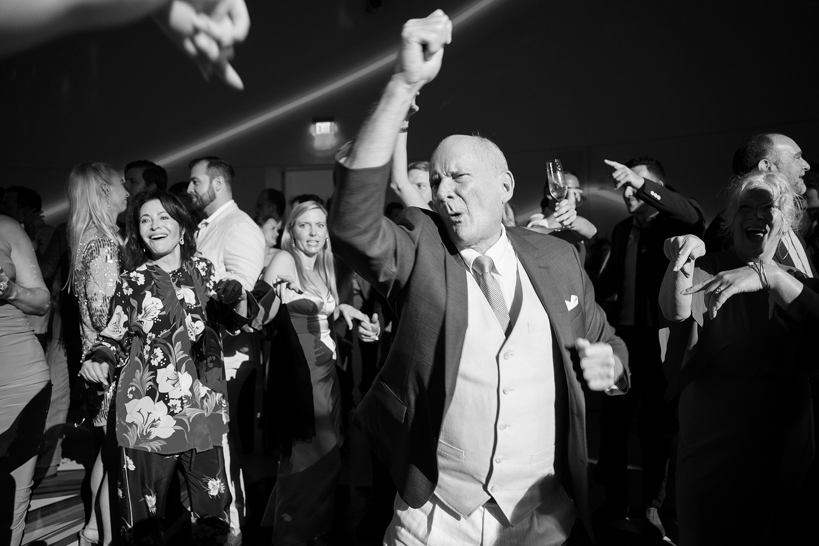 Wedding guest dancing joyfully on the floor during a wedding reception.