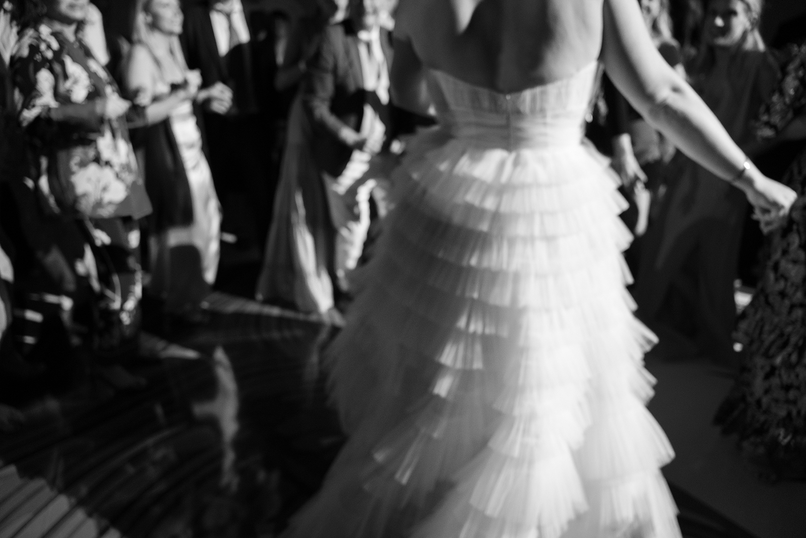 Artistic black and white detail of the bride dancing in her layered gown