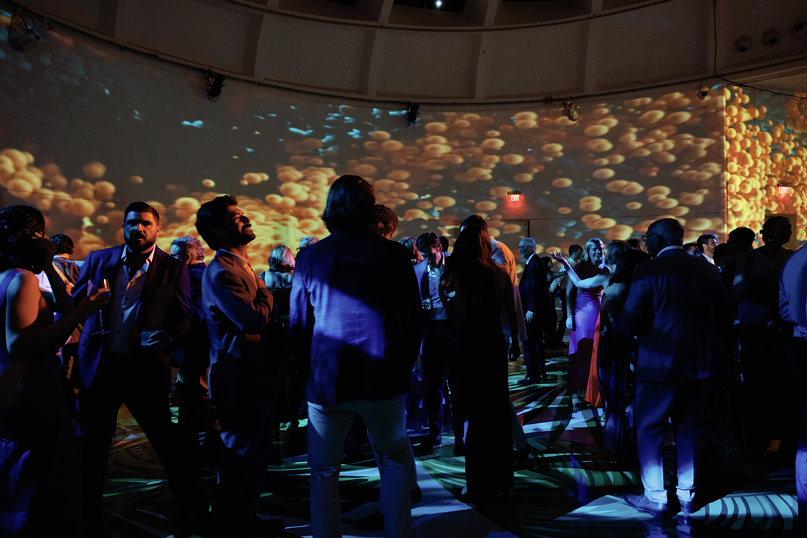 Guests dancing under dramatic projected lighting during a modern wedding reception
