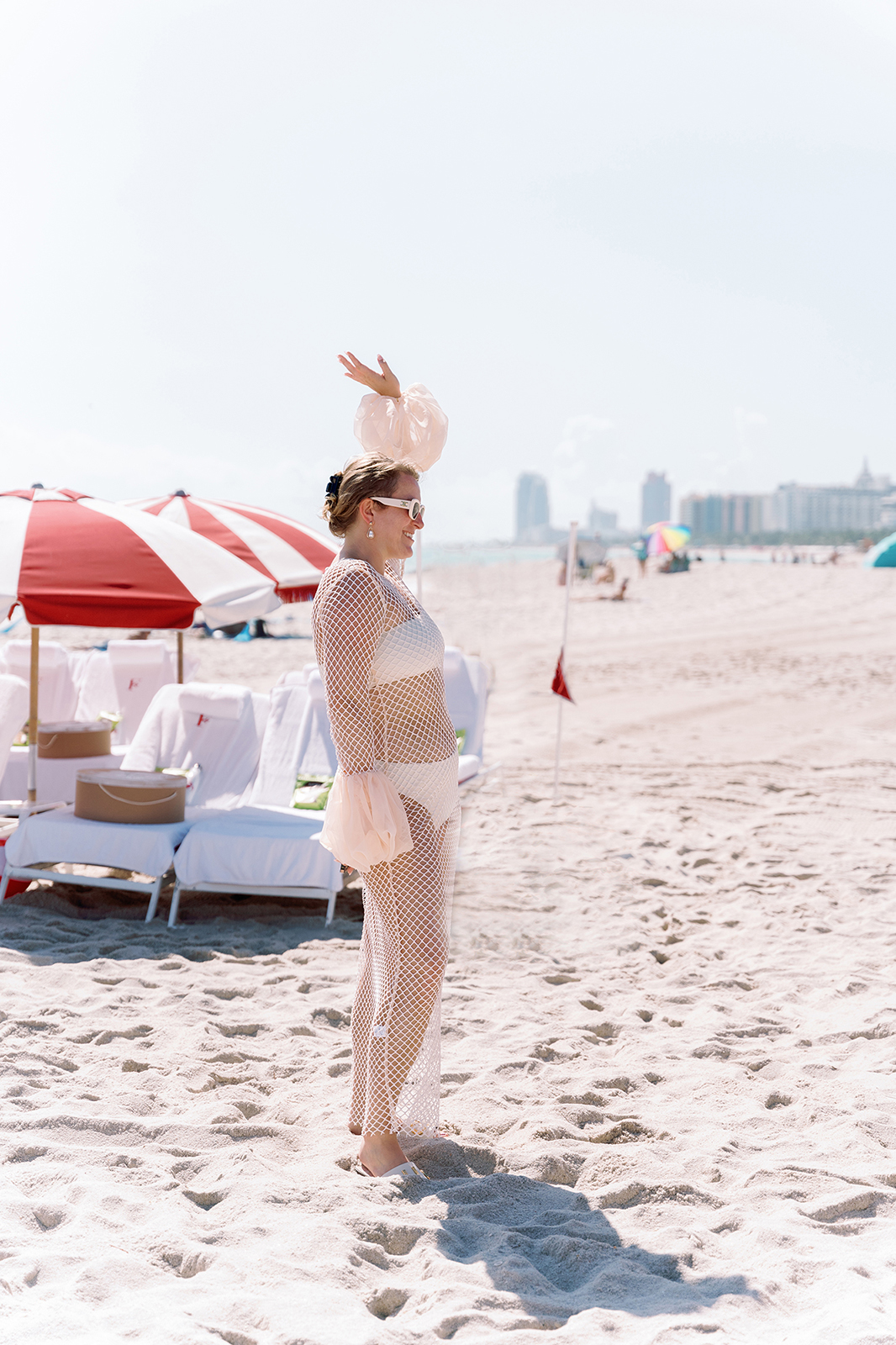Bride waving on Faena Beach in Miami during a relaxed wedding weekend beach party