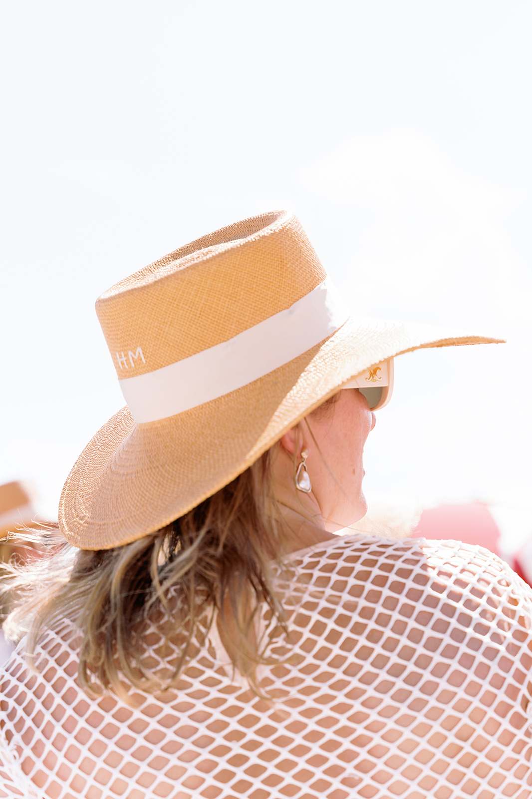 Bride wearing a straw hat at Faena Beach in Miami during a wedding weekend beach party